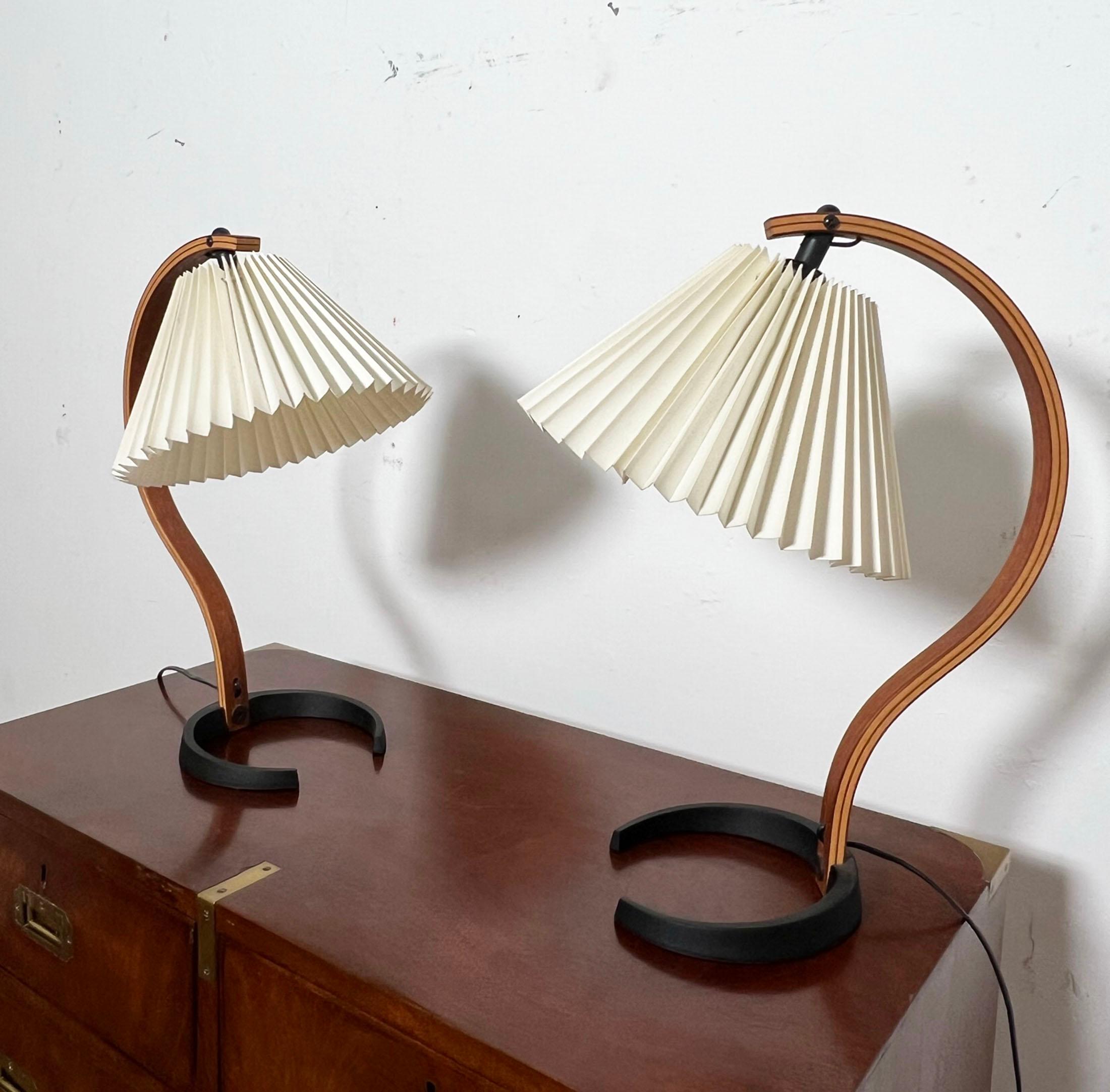 Pair of original 1970s era model 841 Danish lamps with cast iron bases in laminated birch and teak with pleated linen shades designed by Mads Caprani.