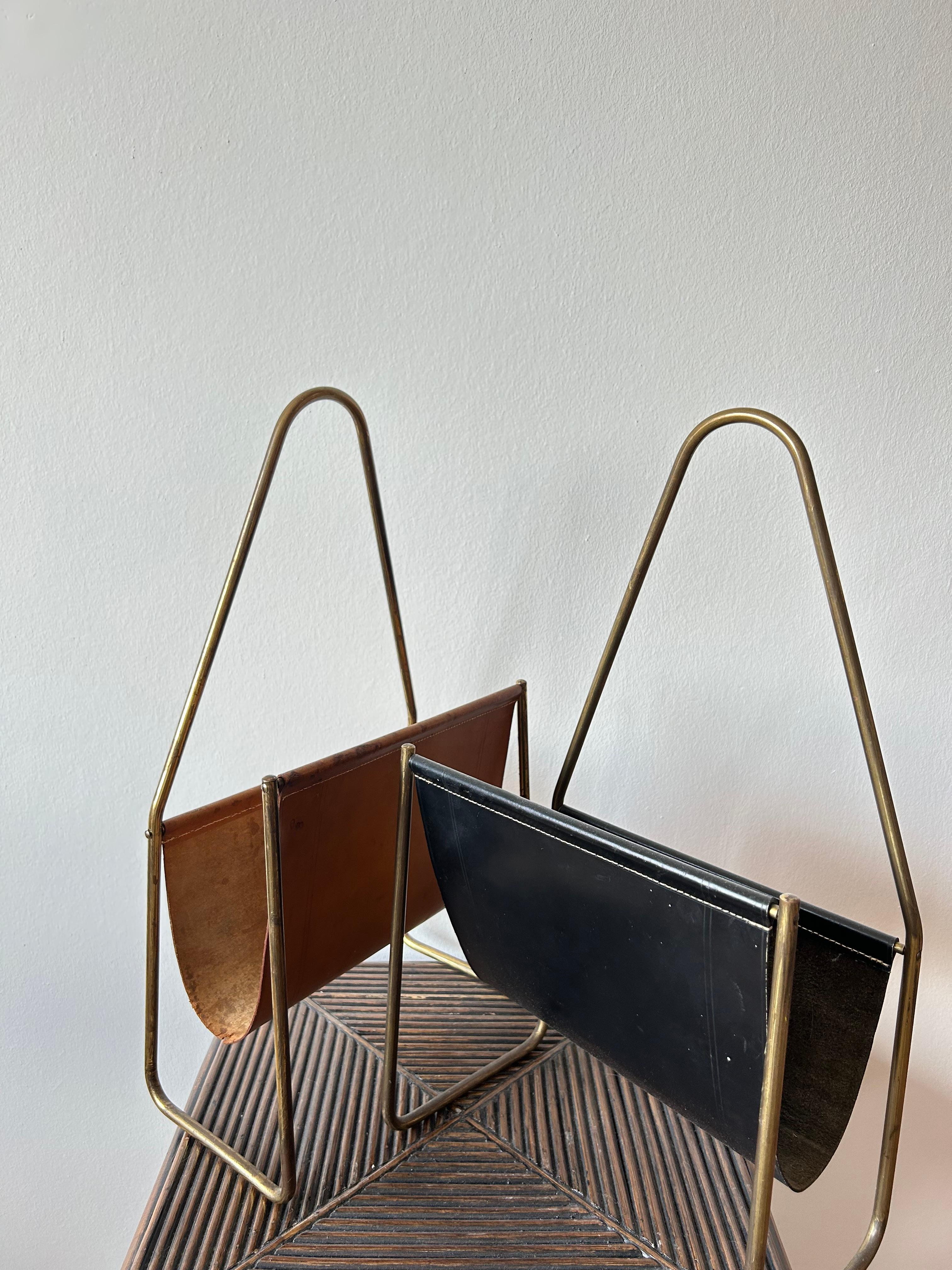 Pair of Magazine holders by Austrian designer Carl Auböck one of them in patinaed brass and thick black leather which only will get more charming over the years, the other one in patinaed brass and brown leather which will also just get more