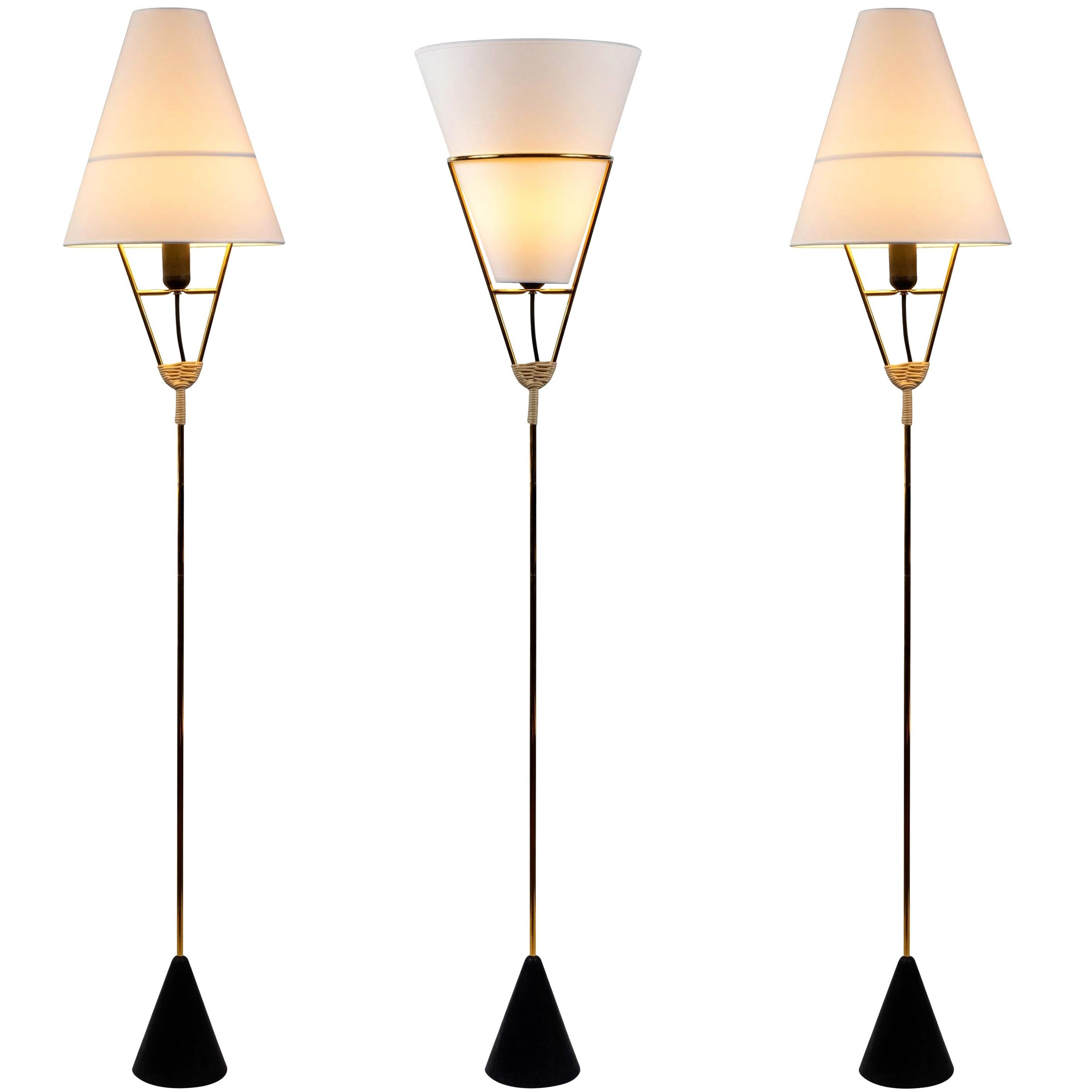 Pair of Carl Auböck vice versa floor lamps. Executed in brass, wicker and cast iron designed by Werkstätte Carl Auböck, Austria, circa 1950. Produced by Carl Auböck IV in the original Auböck Werkstätte in the 7th district of Vienna using the same