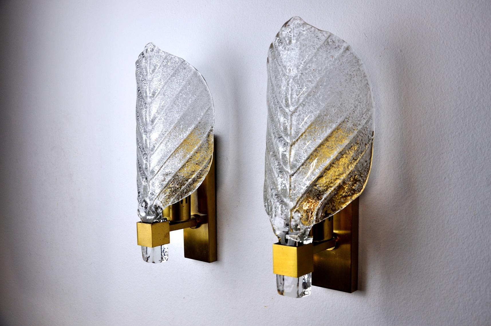 Pair of wall lights by carl fagerlund for lyfa from the 60s. The pair of wall lights is made of brass and leaf-shaped glass. The diffused light is soft and harmonious, perfect for illuminating your interior. Mark of time consistent with the age of