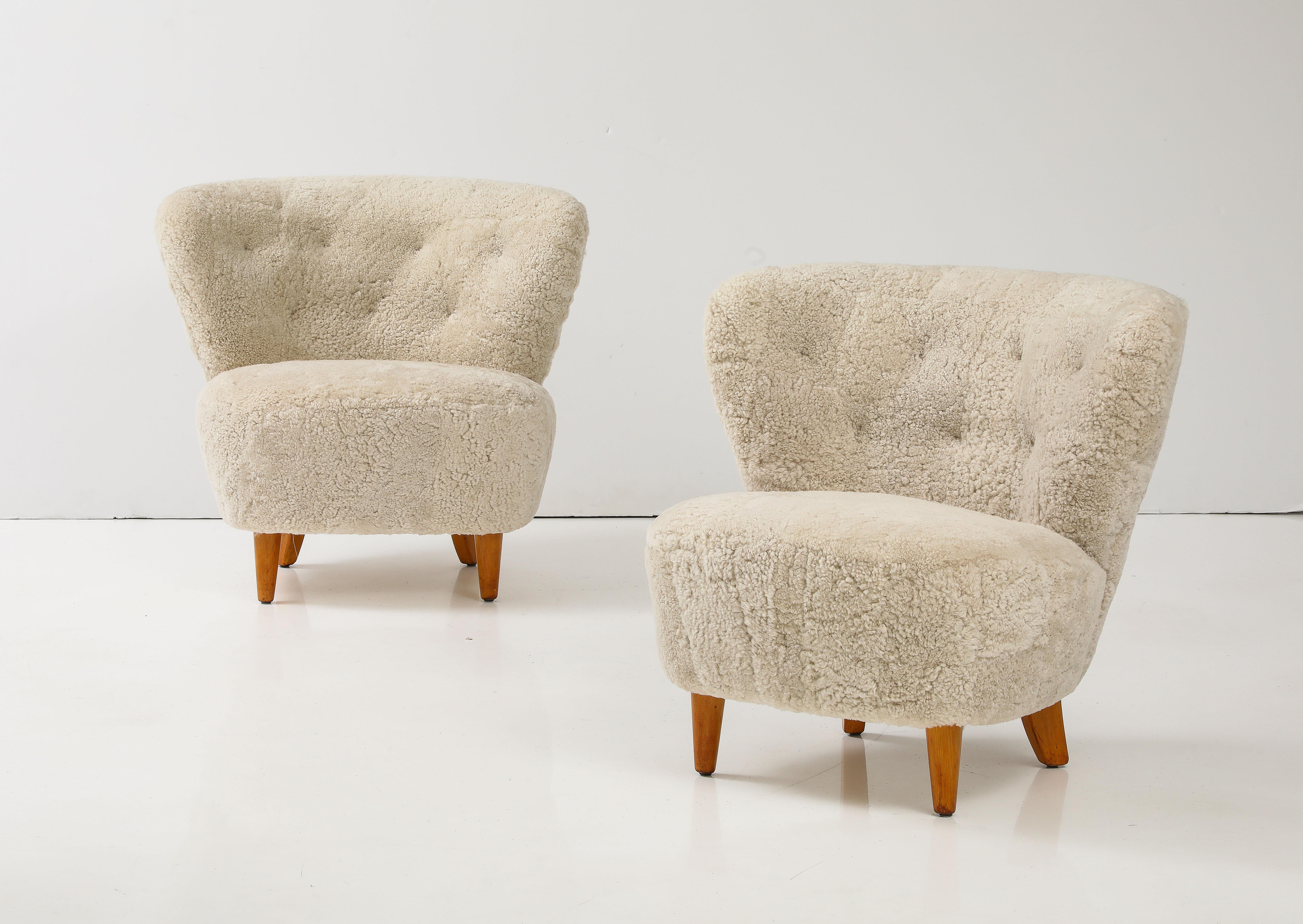 A pair of Carl-Johan Boman (Finnish 1883-1969) club chairs, Circa 1940s
Produced by Oy N. Boman AB, Turku, Finland. With generous curved backrests rand seats raised on birch legs. New off white sheepskin upholstery.
Boman was an educated designer