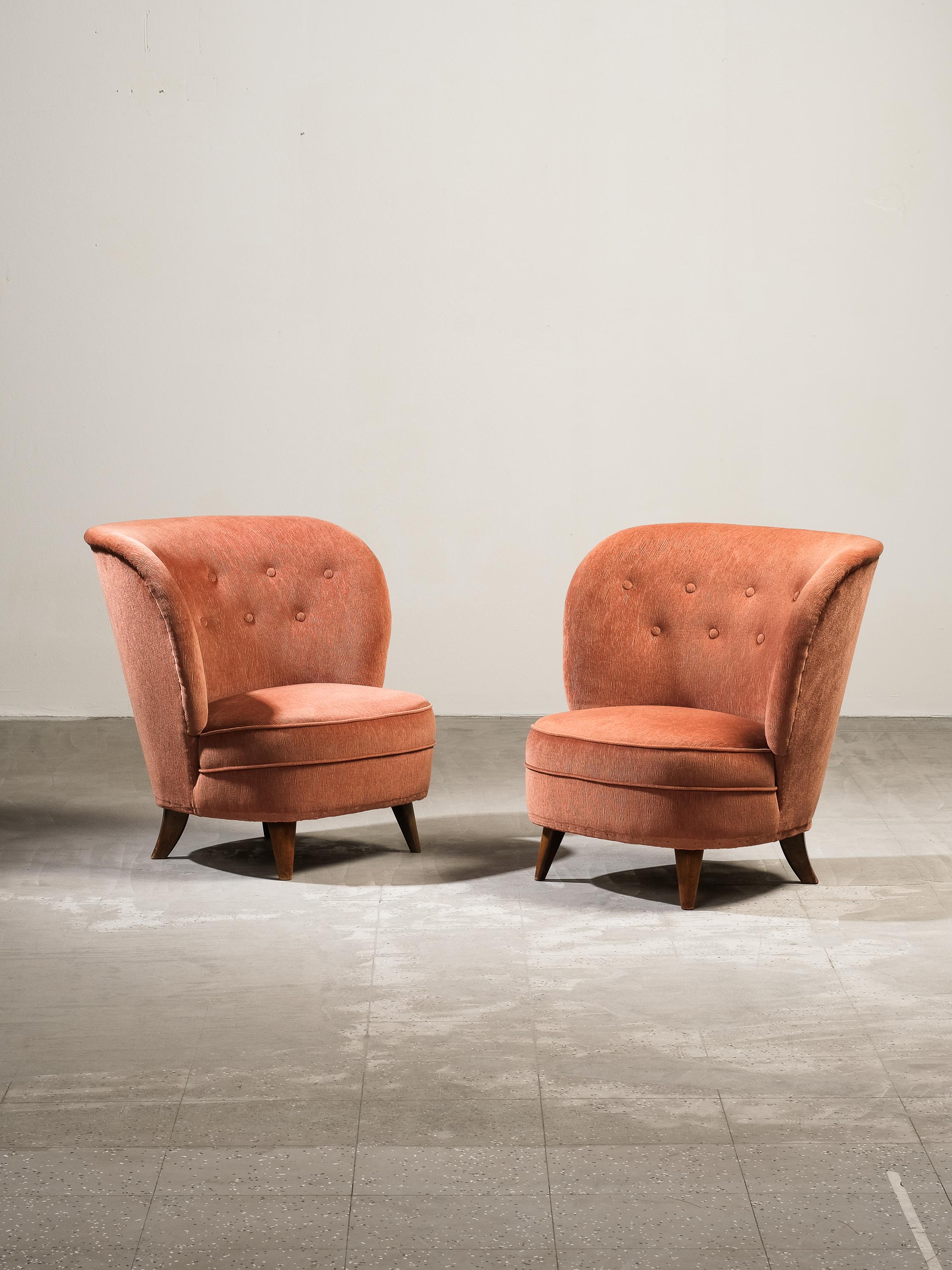 Carl-Johan Boman for Oy Boman AB rare pair of easy, lounge or slipper chairs with elegantly curved backs and tapering stained legs, Finland, 1940s. These exquisite chairs have a classic Scandinavian Modern easy chair form including beautiful curved