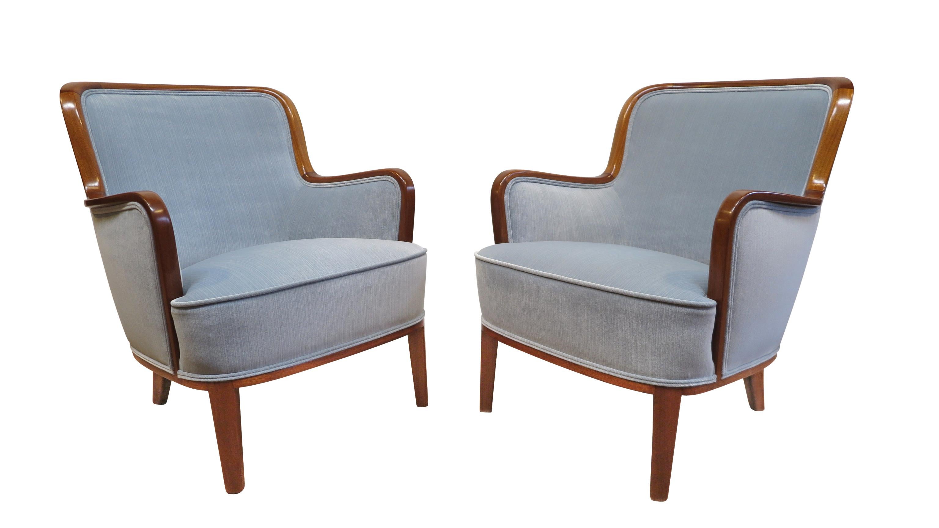 A rare pair of Carl Malmsten easy chairs. Rich sculpted mahogany frames with signature arms newly covered in Nobilis velvet. Excellent condition.