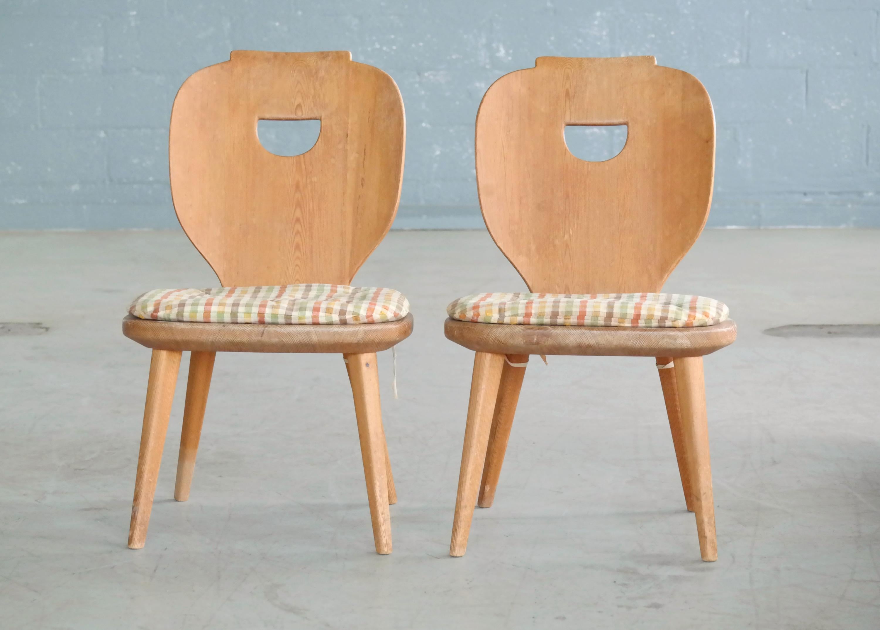 Pair of Carl Malmsten designed side chairs made in Sweden in the 1940s from solid pine. Perfect chairs for the country home or beach house. Has some resemblance to Axel Einar Hjort's famous Lovo chairs. Some signs of natural wear and great natural