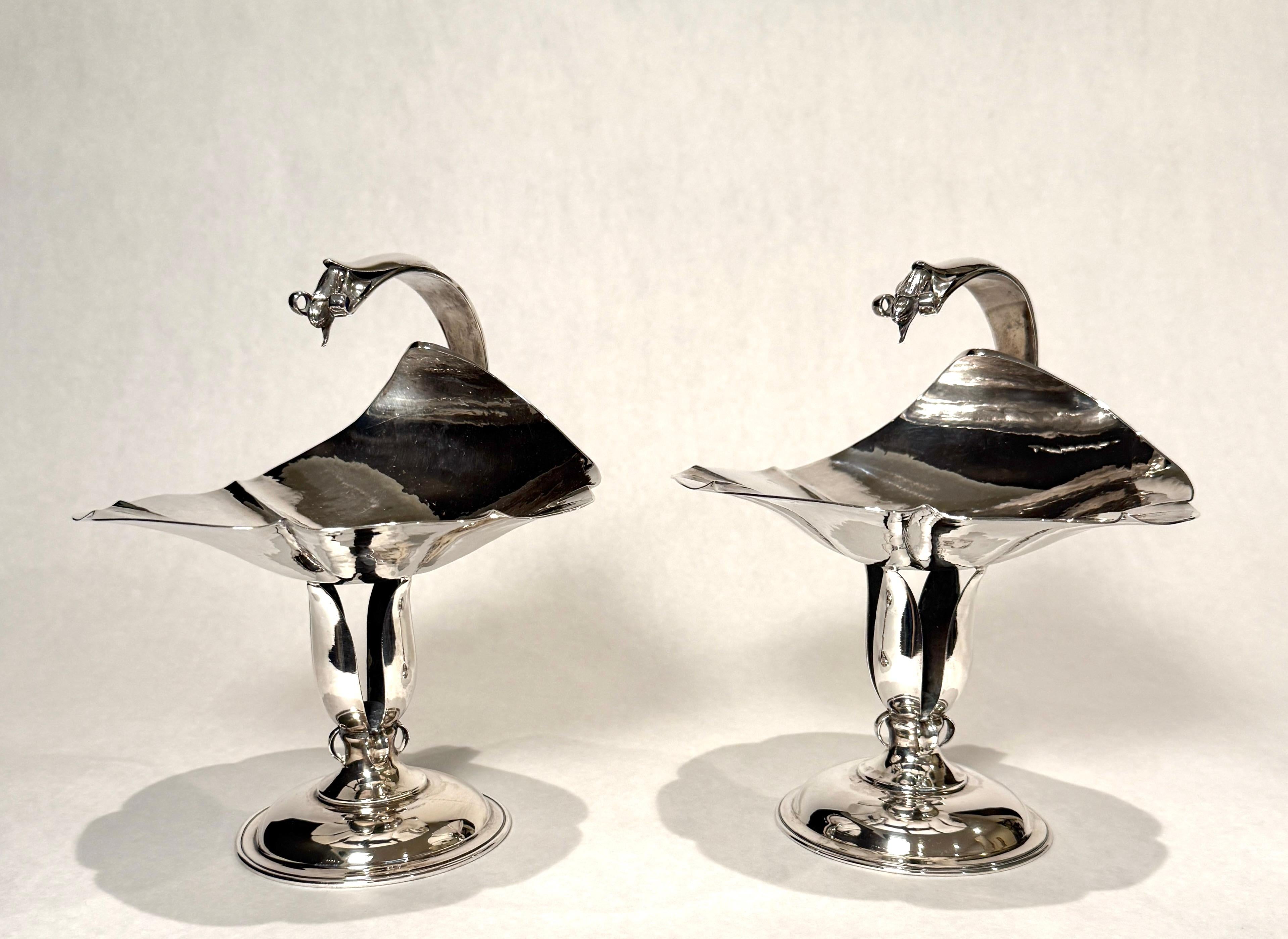 Pareja vintage de compoteras Petersen de plata de ley martillada a mano con motivos orgánicos. Cada uno de ellos está inspirado en sus días con Georg Jensen, con un cuenco martillado con pétalos y un asa curvada terminada en brotes foliados,