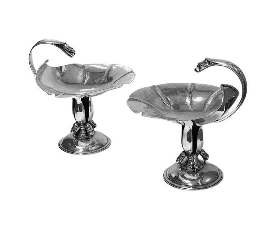 Pair of Carl Poul Petersen sterling silver compotes, Montreal, circa 1940. Each style of Georg Jensen, with a petal hammered bowl and curved handle terminating in foliate buds, supported by four upright leaves with clusters of foliate buds, on a