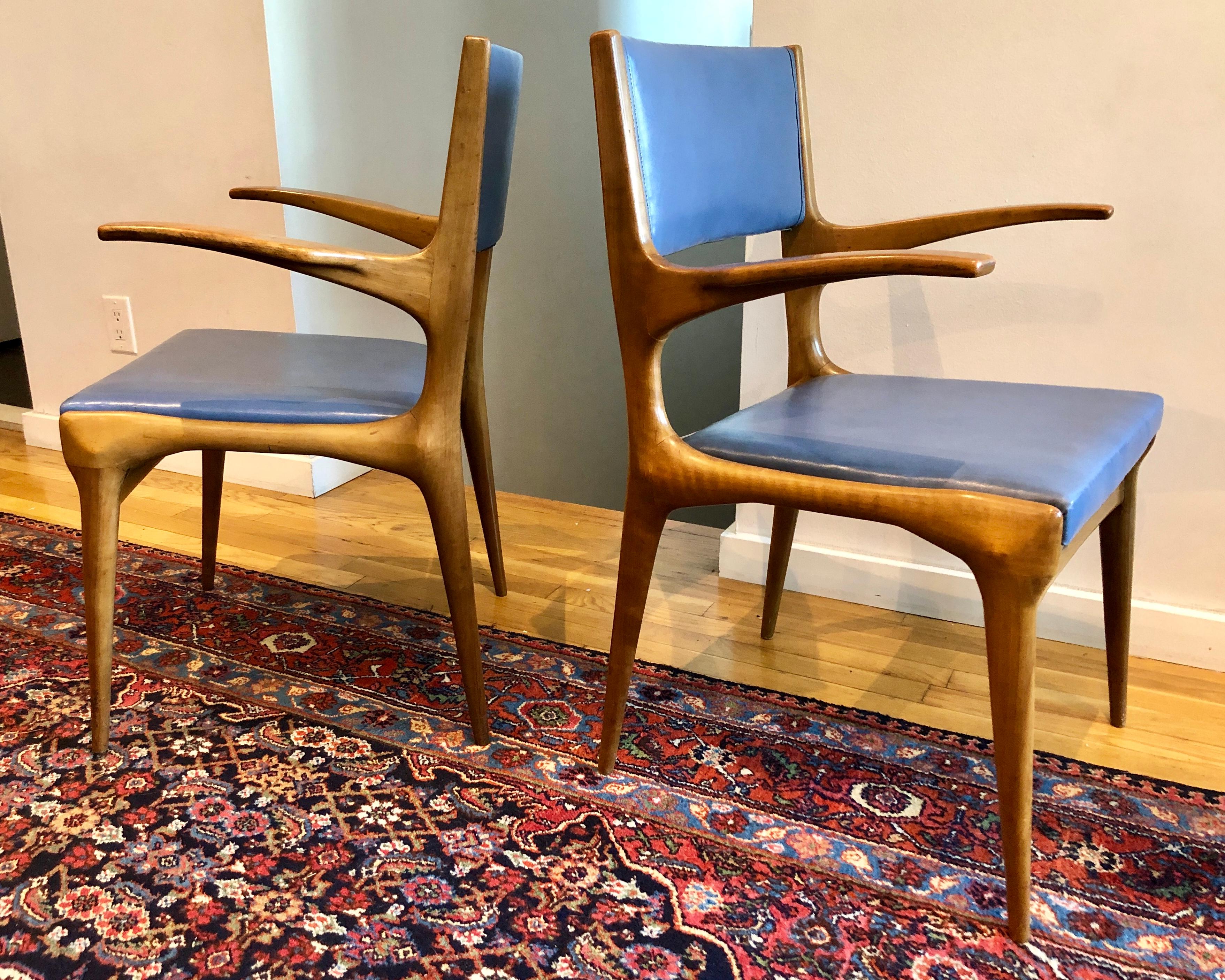 Italian walnut armchair with original blue skai upholstery, beautifully carved with an animal-like fluidity. By Cassina, retailed through M. Singer & Sons.
