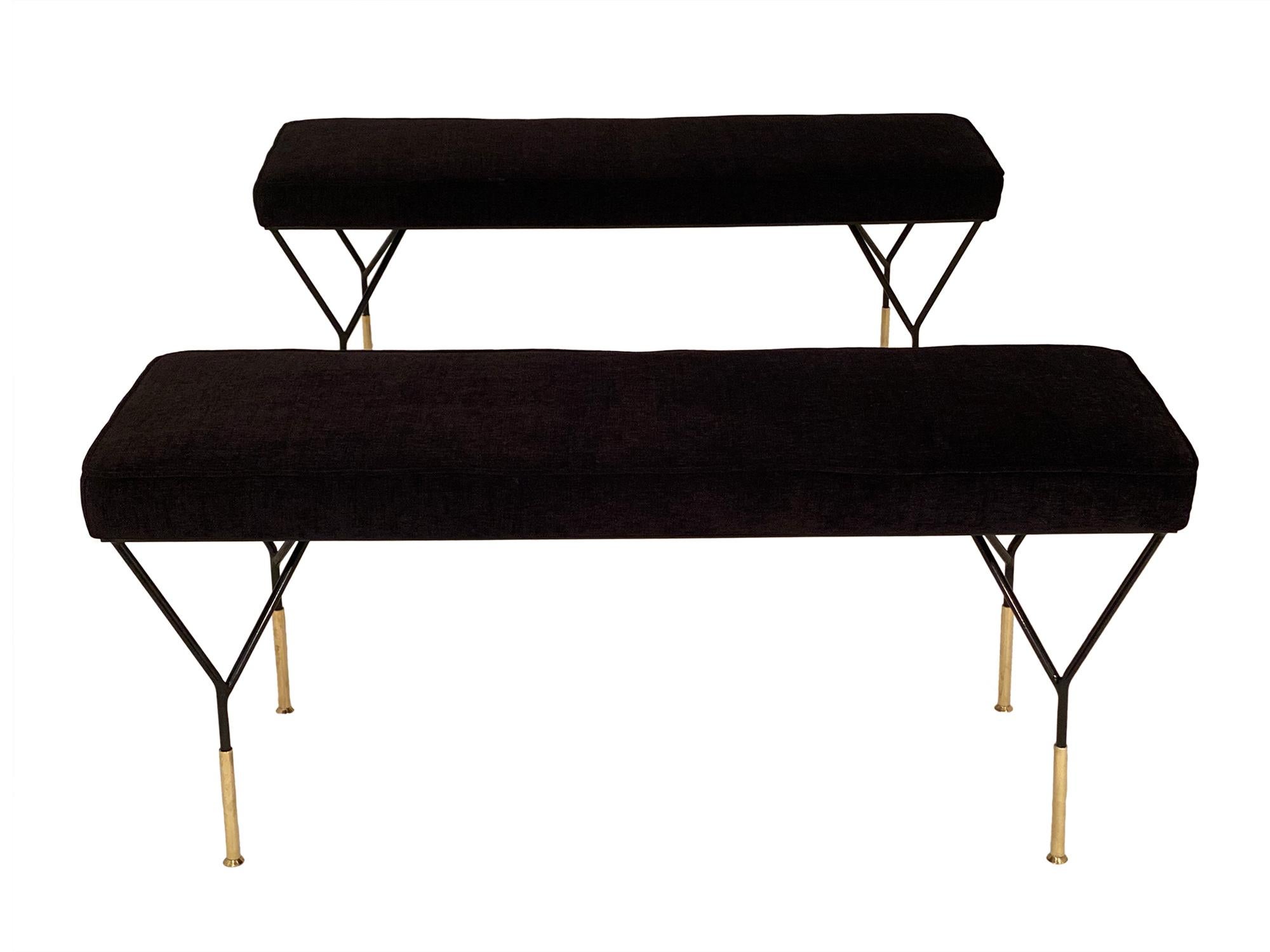 Pair of benches in the manner of Carlo di Carli. This Italian pair has black lacquered steel bases with solid gilt brass feet and a navy blue upholstery.