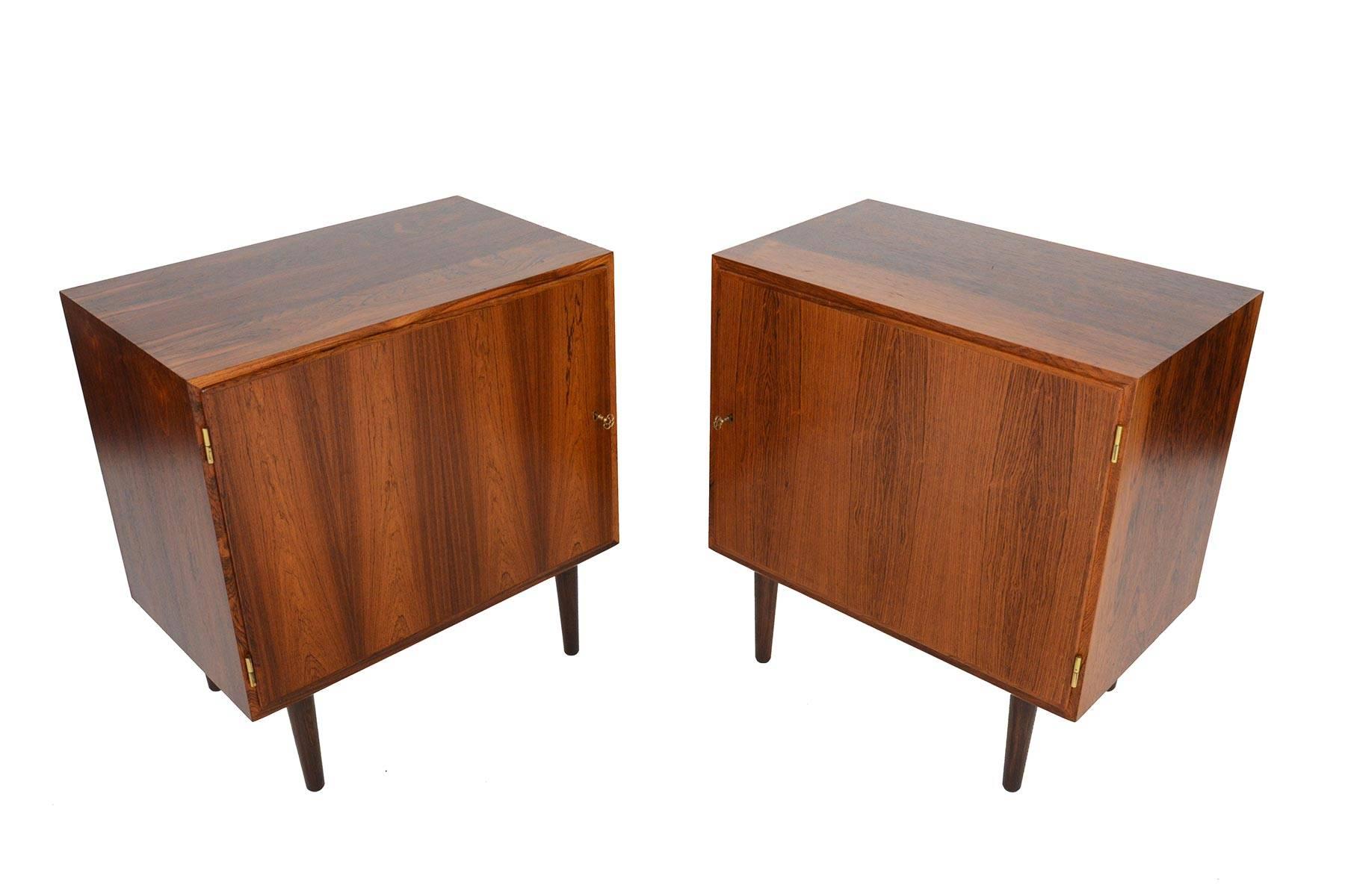 This pair of Danish modern Brazilian rosewood nightstands model HD 40 was designed by Carlo Jensen for Poul Hundevad in the early 1960s. This unique pair are identical but open from opposite sides making them perfect to pair with a bed or sofa. The