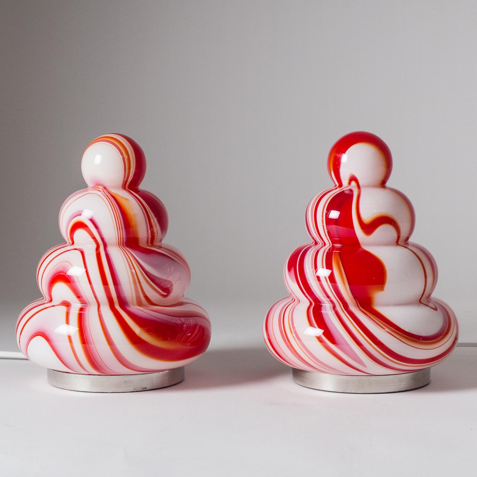 Tolles Paar rot-weißer Murano-Glas-Tischlampen von Carlo Moretti aus den 1960er Jahren. Die abgerundete Reifenform und die kühne, wirbelnde Farbe sind eine klare Anspielung auf die Pop-Art-Ästhetik dieser Zeit. Sie sind in sehr gutem Originalzustand
