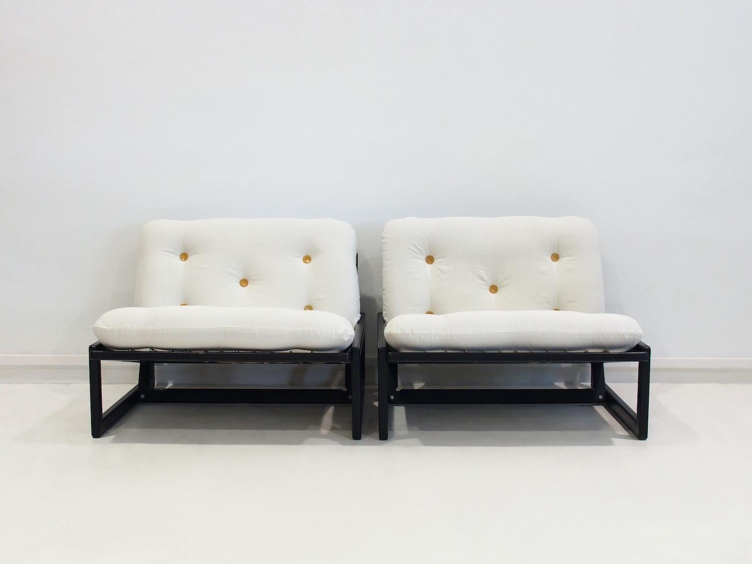 Pareja de butacas Carlotta diseñadas por Afra y Tobia para Cassina, hacia 1967. Las sillas tienen un sencillo armazón rectangular de madera lacada en negro que ha sido restaurado. El cordón elástico tejido sostiene los cojines móviles del respaldo y
