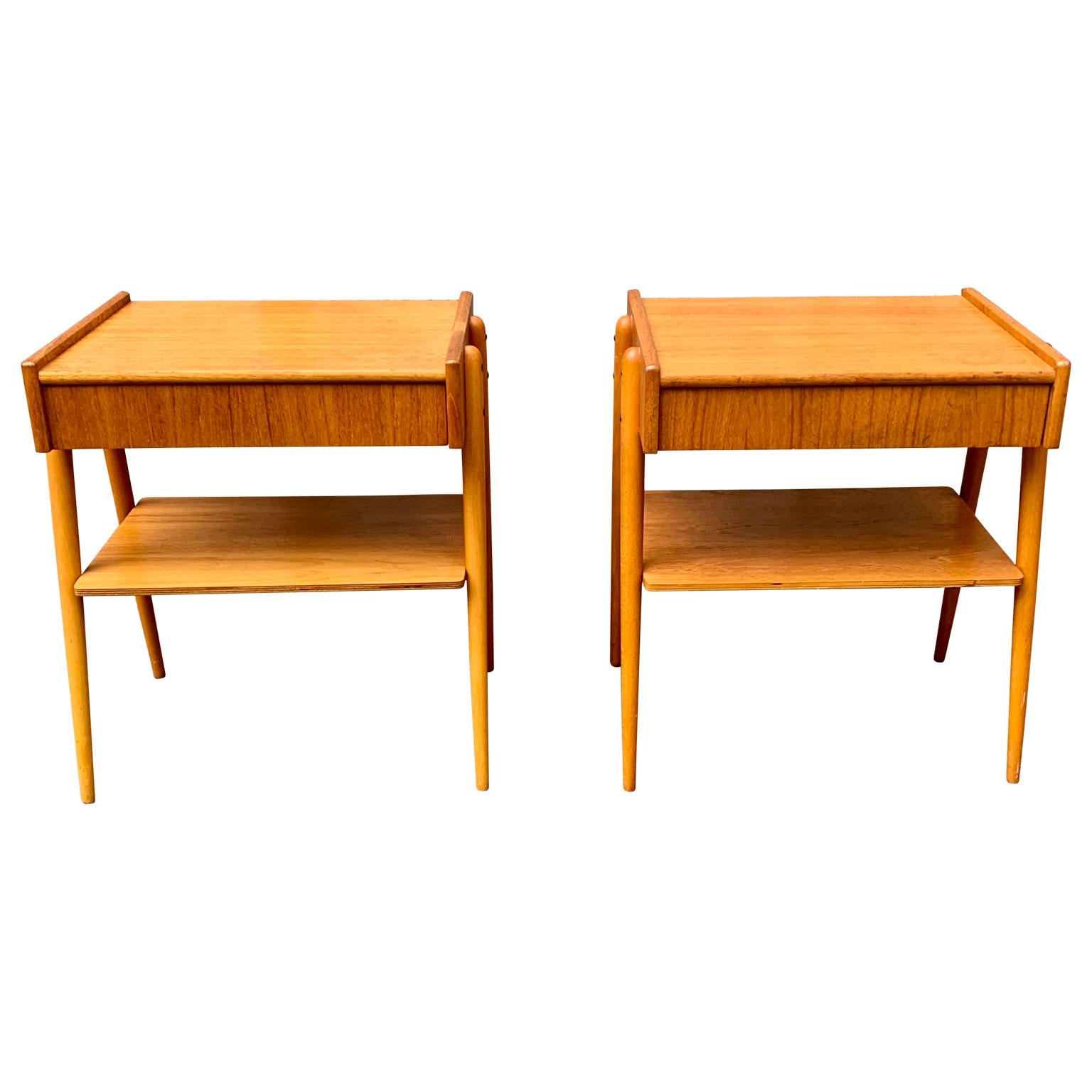 A pair of Swedish vintage nightstands or small night tables in teak wood.
The rounded legs of these bed side tables are made in beech wood and the pair each have a drawer and a shelf underneath for magazines. This pair of Scandinavian bedroom
