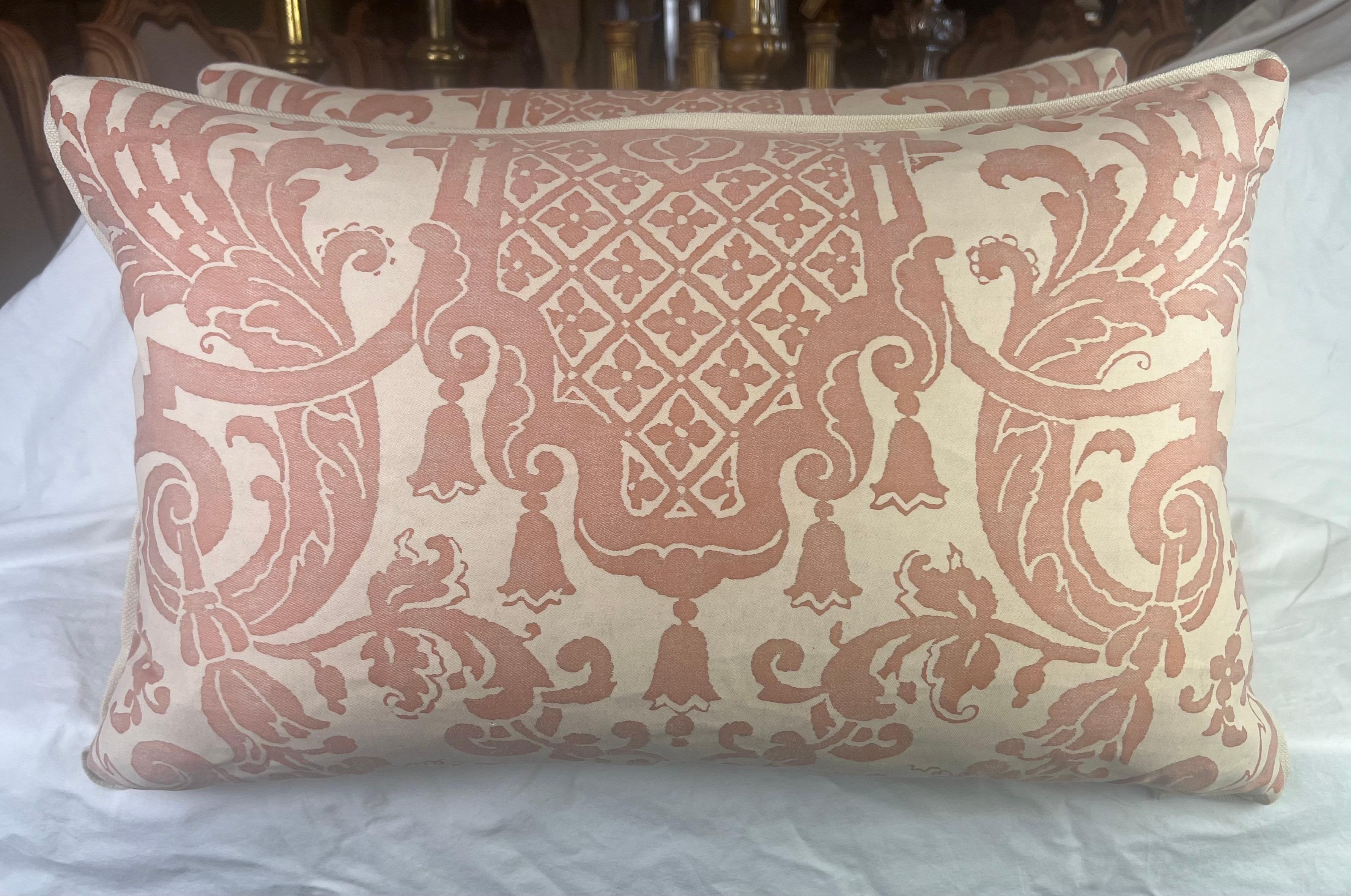 Ein Paar Kissen aus Fortuny-Stoff mit Carnavalet-Muster in Rosa und Creme.  Das vom 17. Jahrhundert inspirierte französische Design - mit prächtigen und komplizierten Gartenurnen, die reichlich mit Blumen geschmückt sind - wird von üppigen