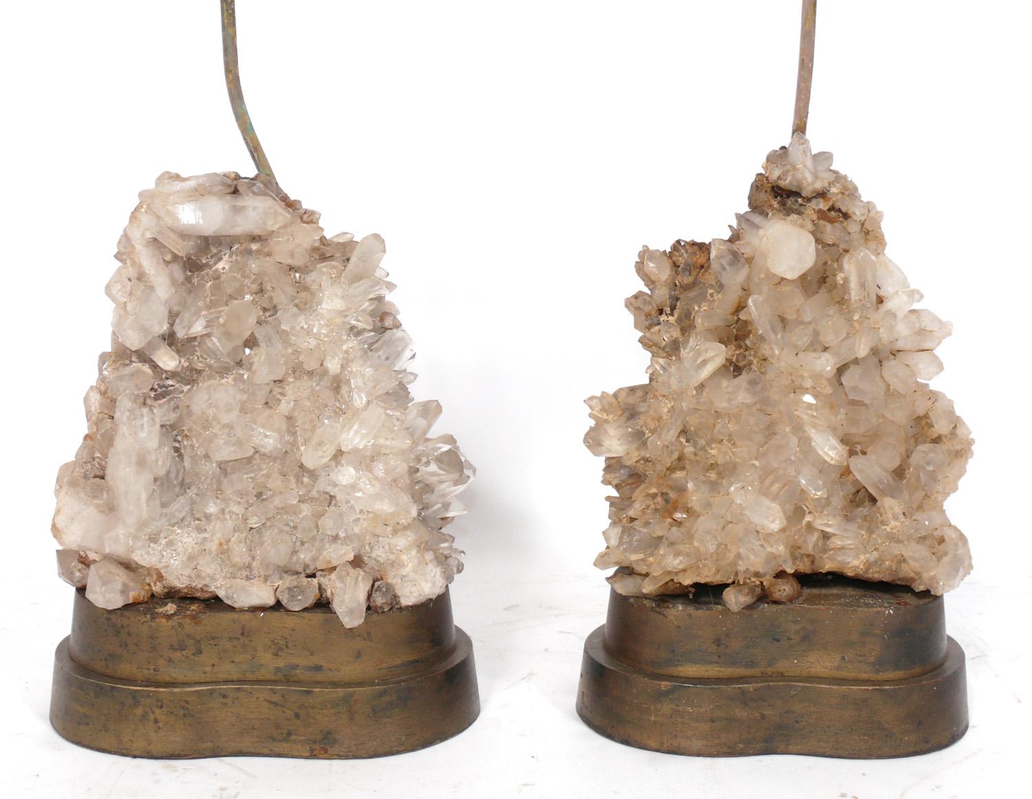 Pair of glamorous rock crystal lamps, designed by Carole Stupell, American, circa 1950s. They retain their original curvaceous silk shades. They have been rewired and are ready to use. They retain their warm original patina.