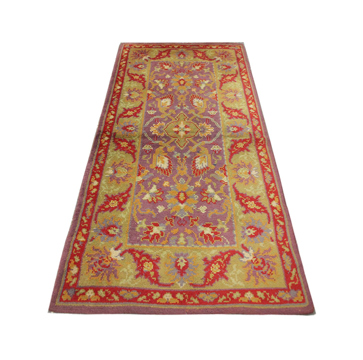Un vibrante diseño botánico empapa esta alfombra británica vintage Axminister de alta calidad, con diseños de motivos florales simétricos, tejida a mano en 1890 con lana y algodón hilados a mano y teñidos con tintes vegetales, por algunos de los