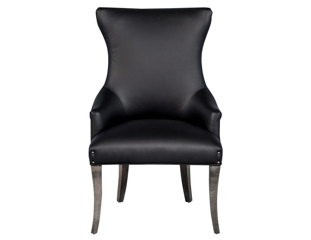 Pair of Carrocel modern opus custom leather upholstered modern parlor chairs. Classic Carrocel curvaceous opus arm chairs upholstered in opulent Italian black leather adorned with hand applied pewter head to head furniture nails. These chairs are