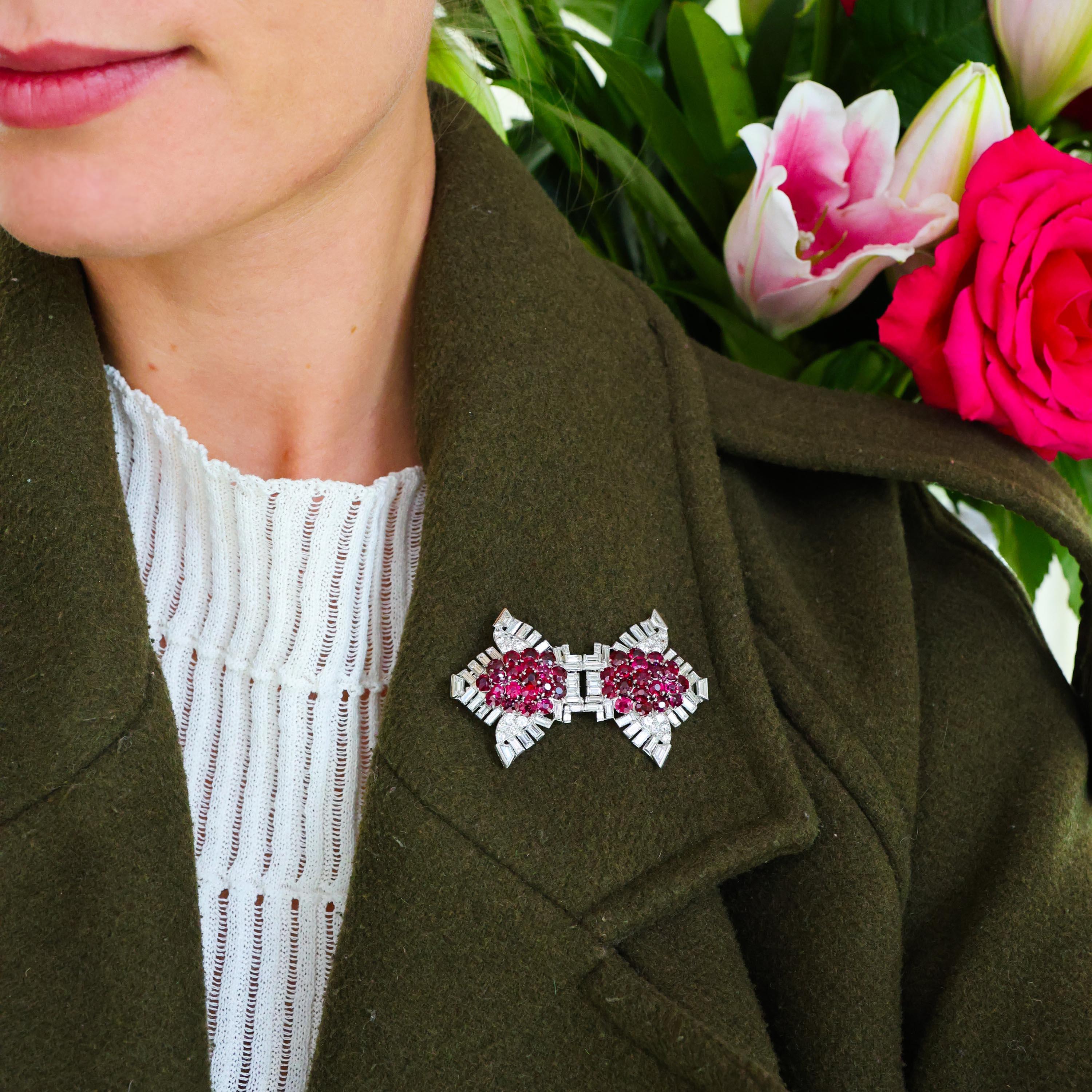 A pair of Cartier, Art Deco, ruby and diamond double clips, with a triple row, raised, bombé cluster of faceted, round and cushion shaped rubies, in claw settings, flanked by pavé set round brilliant-cut diamonds, in leaf shaped mounts, with a