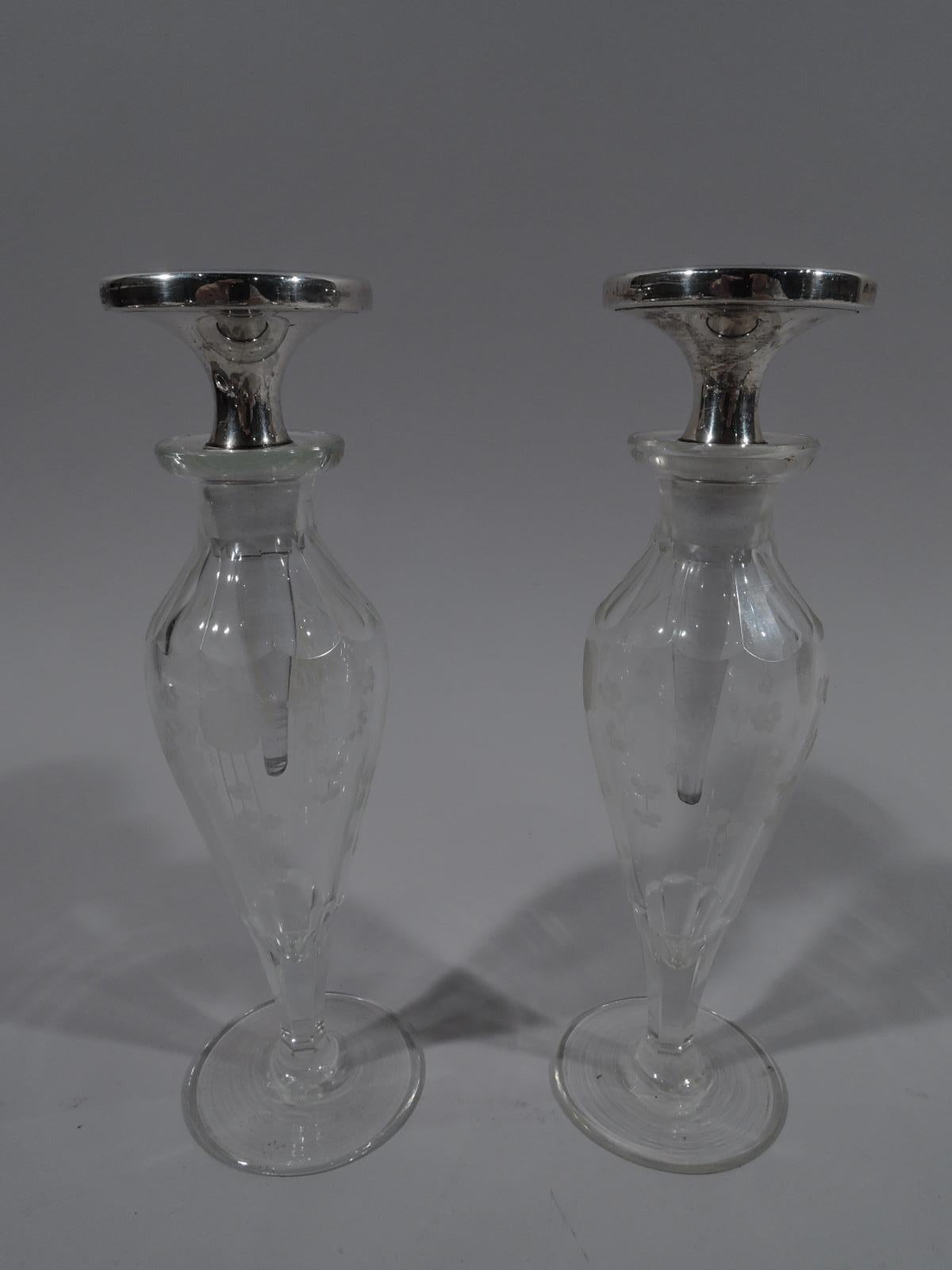 Pair of Art Deco, sterling silver, enamel, and crystal perfumes. Retailed by Cartier in New York, ca 1920. Each: Crystal baluster bottle with flat circular foot, cut lobed shoulder, and short neck. Etched stylized flowers. Disc stopper with