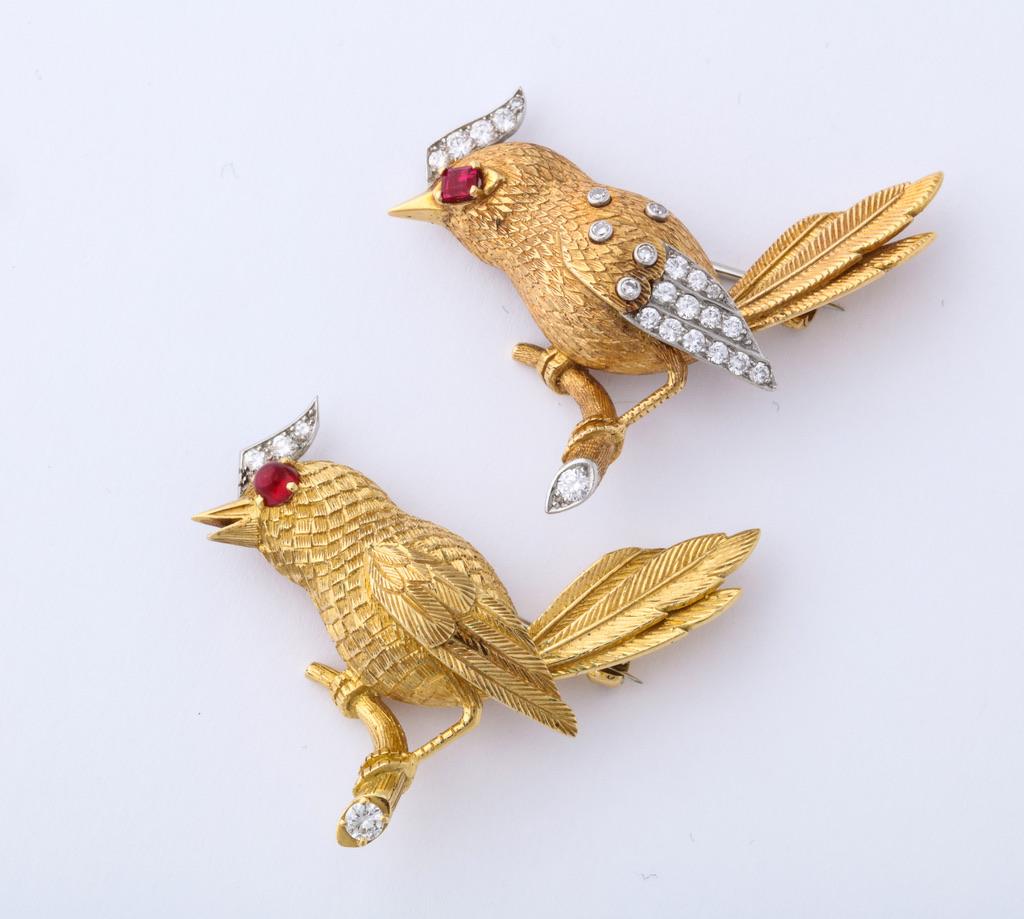 A wonderful pair of textured gold, ruby and diamond bird brooches by Cartier.  Both are signed and numbered, while one has English hallmarks indicating that it was made in London in 2007.  It is likely that this brooch was commissioned in order to