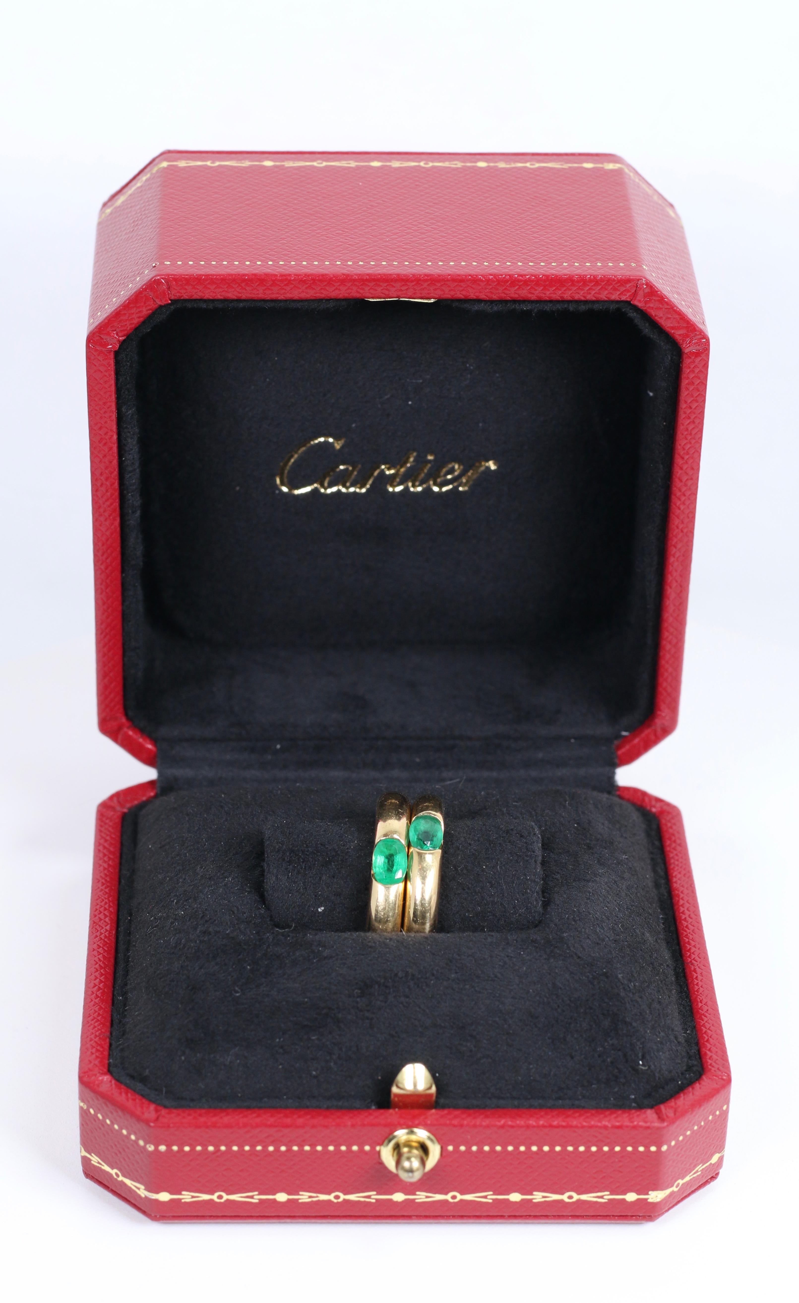 Pair of Cartier Yellow Gold Bands with Single Emeralds with Box and Papers. Size 7.25