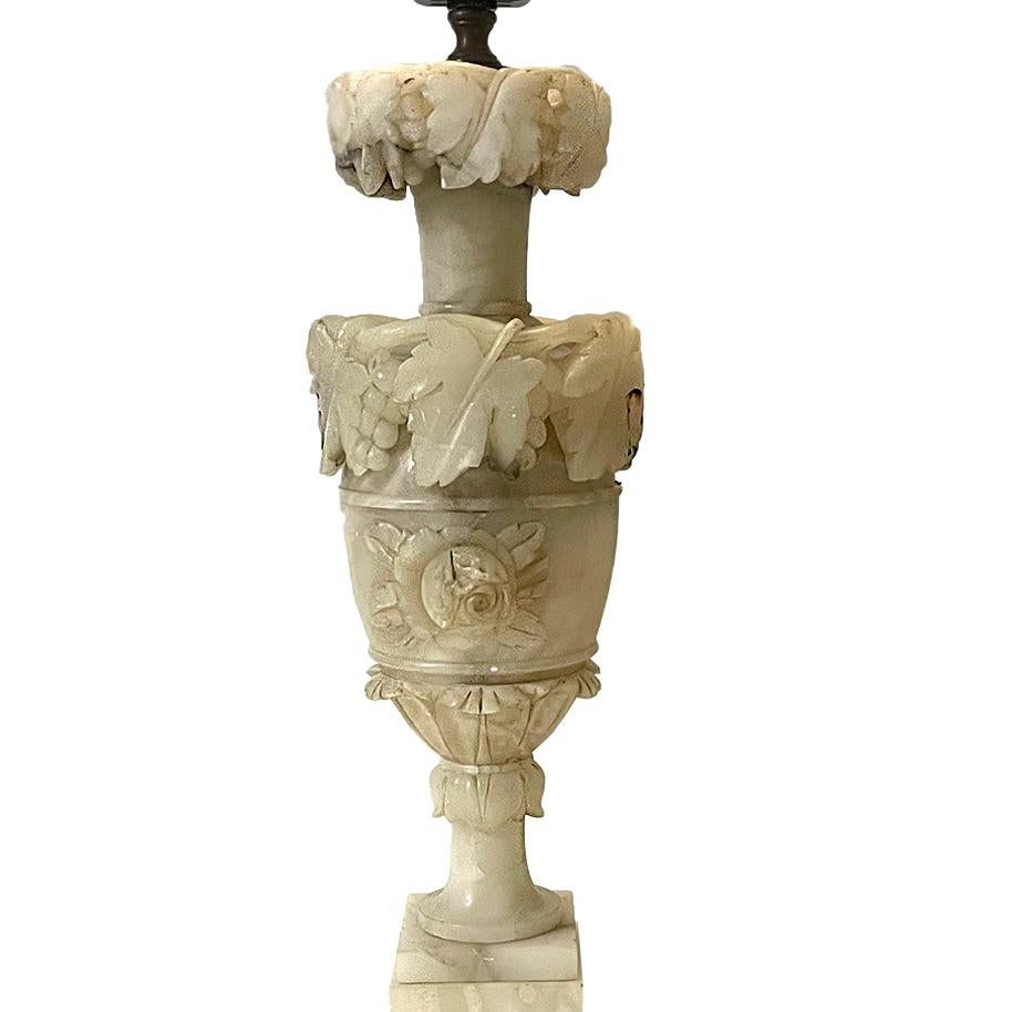 Pair of circa 1920's Italian carved alabaster table lamps with foliage motif on body and with pedestal base.

Measurements:
Height of body: 19