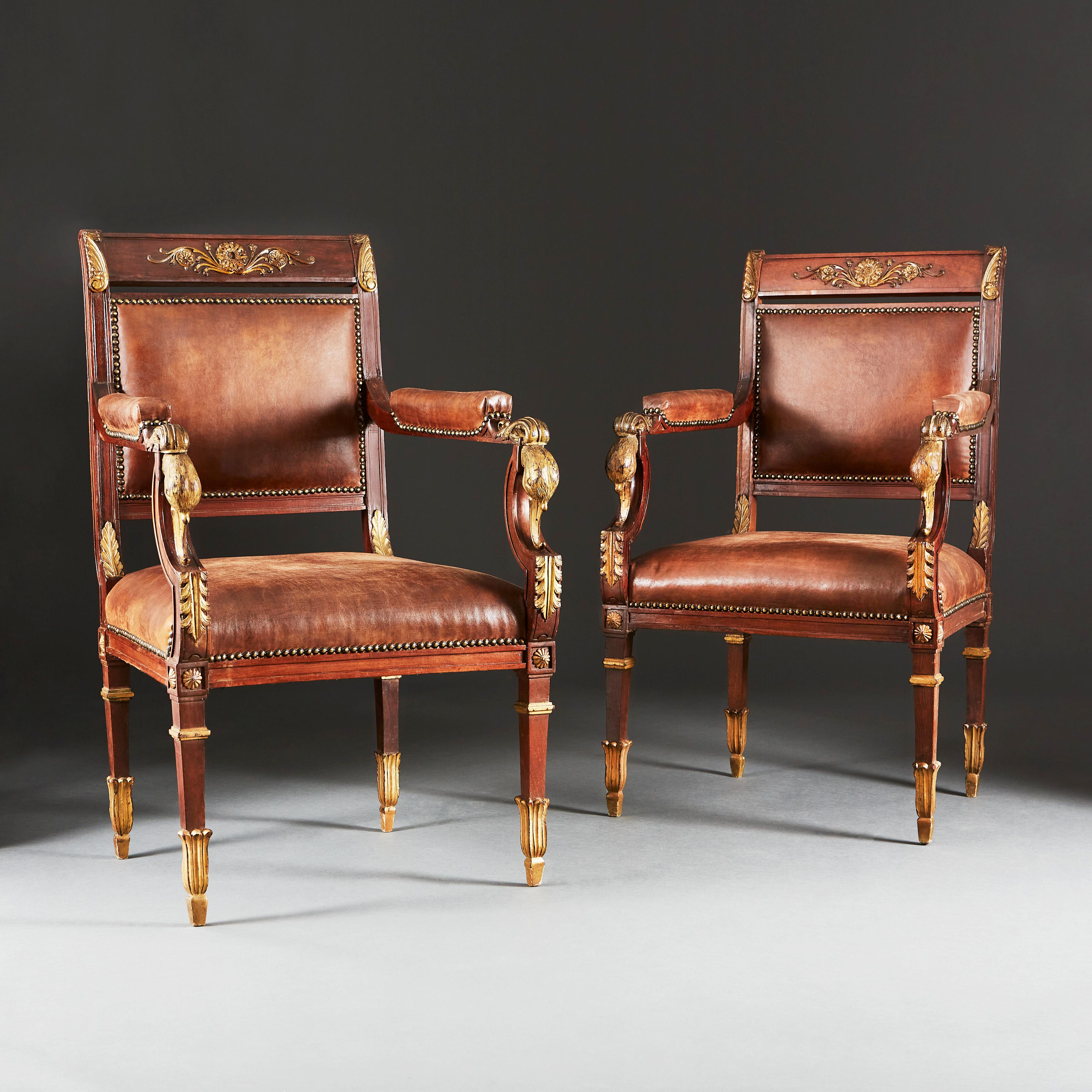 Ein Paar geschnitzte und vergoldete Sessel im Empire-Stil. Die Mahagoni-Rahmen mit geschnitzten und vergoldeten Schwanenköpfen an den Armlehnen und der Jansen-Rosette an den Spitzen der sich verjüngenden Beine. Die Rahmen wurden mehrfach mit einer