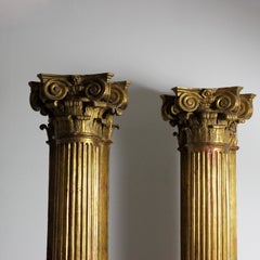 Pair of carved and gilded wall columns with fluted shafts and capitals topped