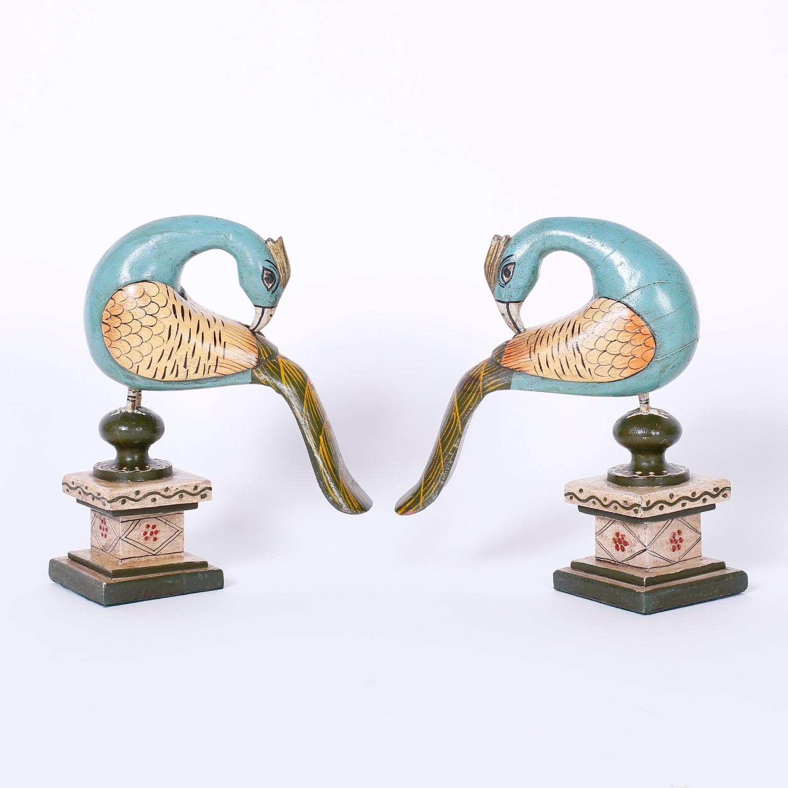 Vintage pair of Anglo-Indian stylized peacocks crafted with wood, carved and painted in tropical colors. Presented on Classic painted wood stands.
 