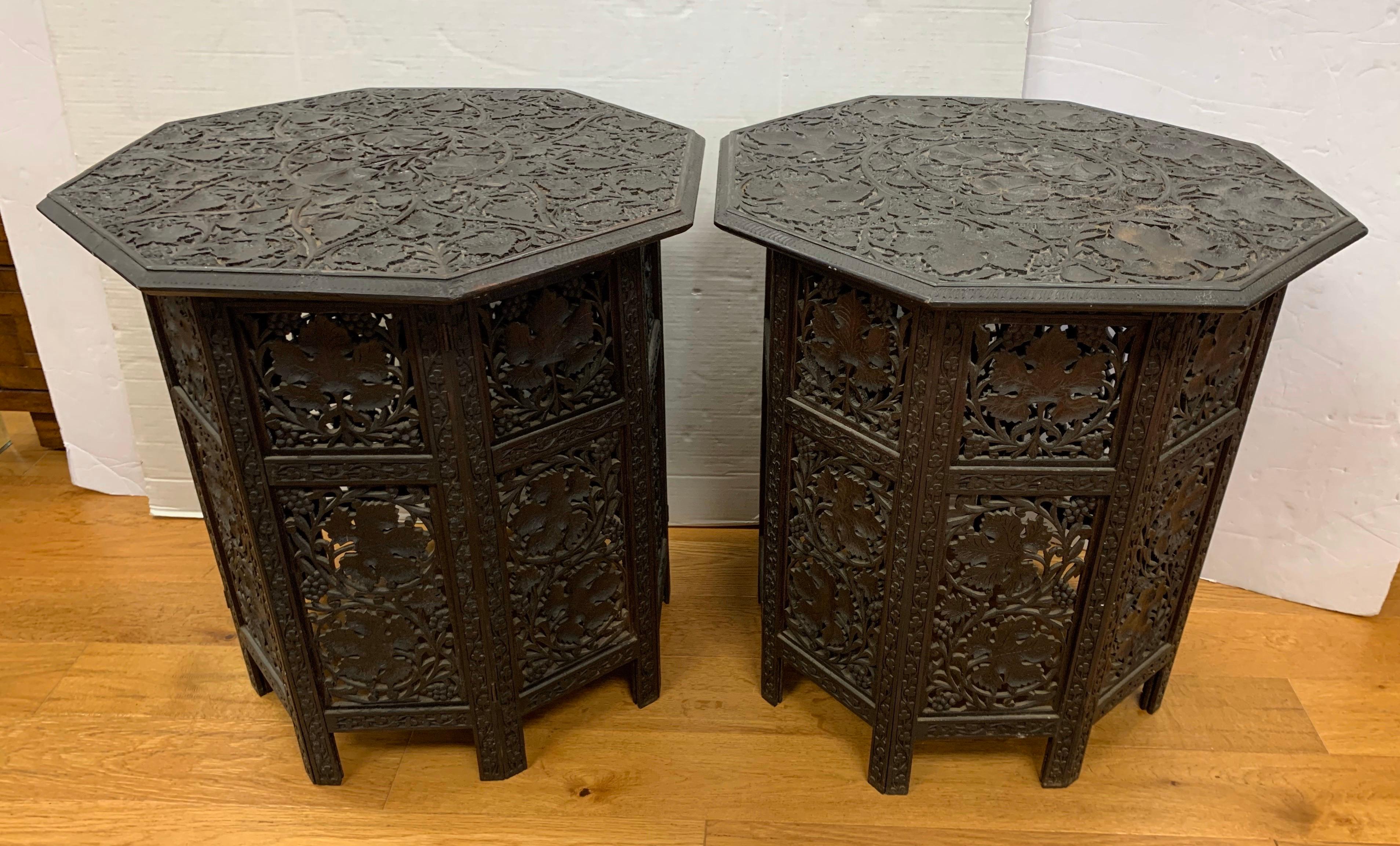 Anglo-Indian carved hardwood octagonal occasional table dating from the early 20th century. It has a removable top and an eight sided folding base, both intricately carved with grape vines.