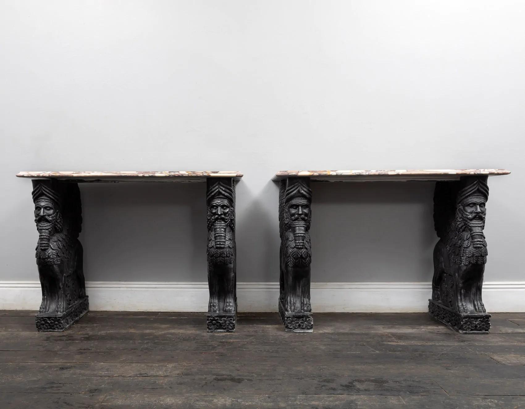 A stunning pair of carved black marble and coloured Medicea Siena marble topped console tables
The uprights carved from solid blocks of pure black marble in the form of Lamassu. The Italian Medicea Siena marble tops with moulded edges rests on top.