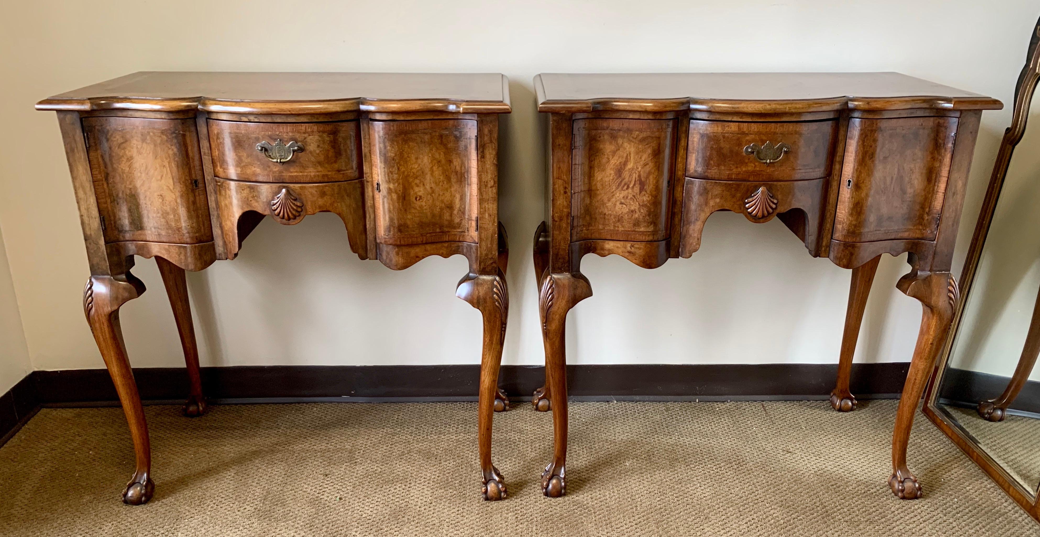 Coveted pair of matching carved burled walnut console tables with black lacquer and gold hand painted mirrors above. The table has storage and key to lock which make the possibilities endless. Dry bar, console table, accent table, foyer piece - your