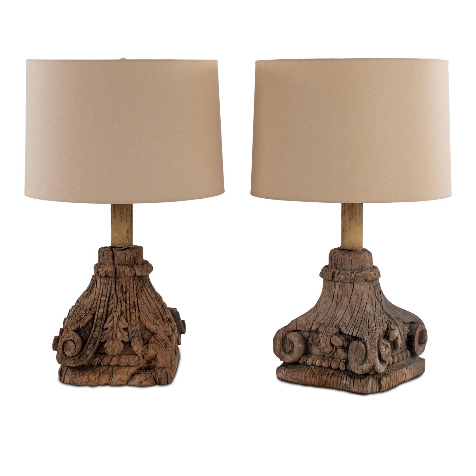 Pair of carved capital table lamps, custom table lamps created from hand carved 18th century architectural fragments. Mounted on custom wood stands. Newly wired for use within the USA using all UL listed parts. Include beige linen shades.