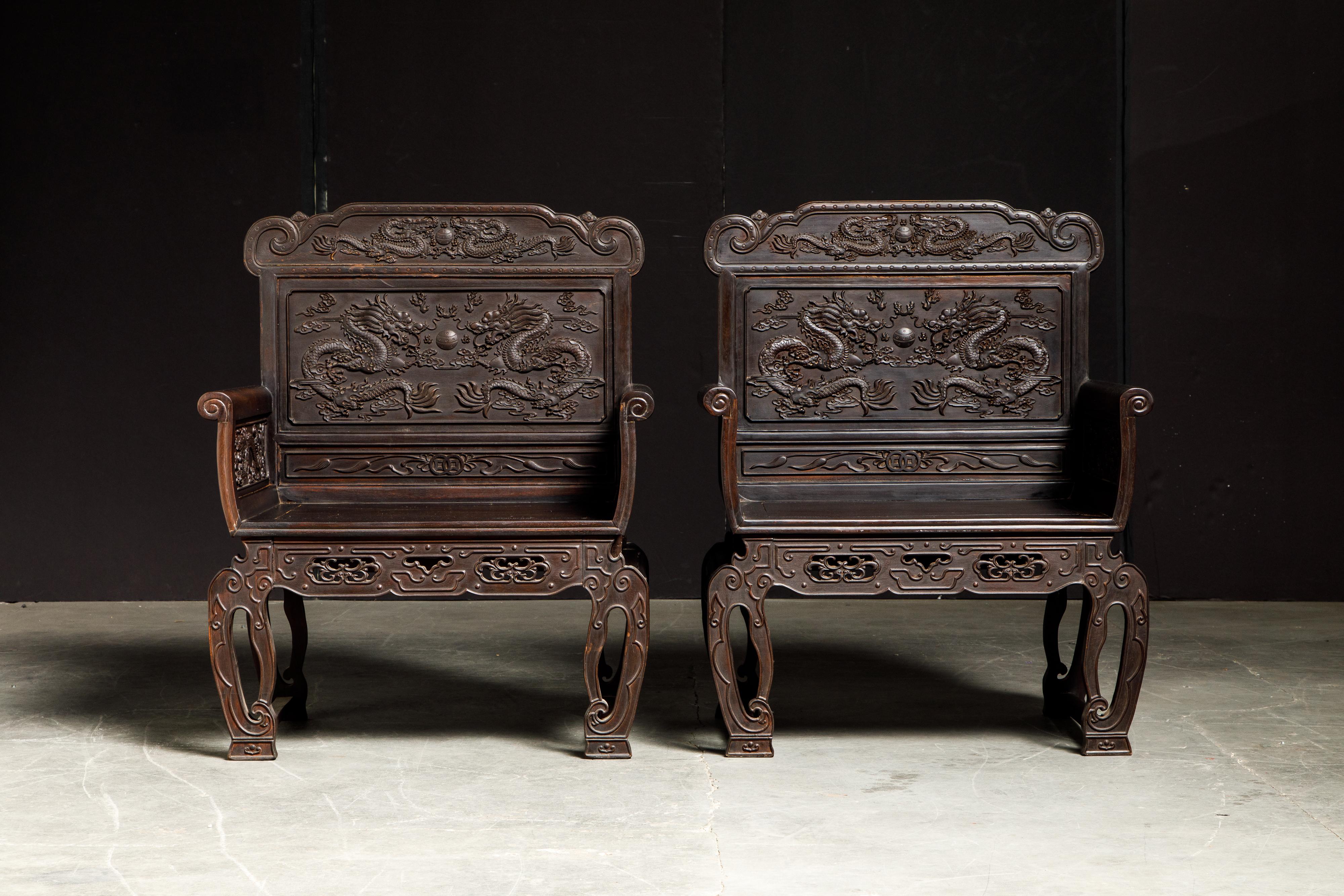 This incredible pair of highly detailed carved throne chairs feature carved aprons, legs and scrolled arms with back and side panels carved with dragons and flaming pearl motifs.  Attributed to late 19th / early 20th century, we believe this to be
