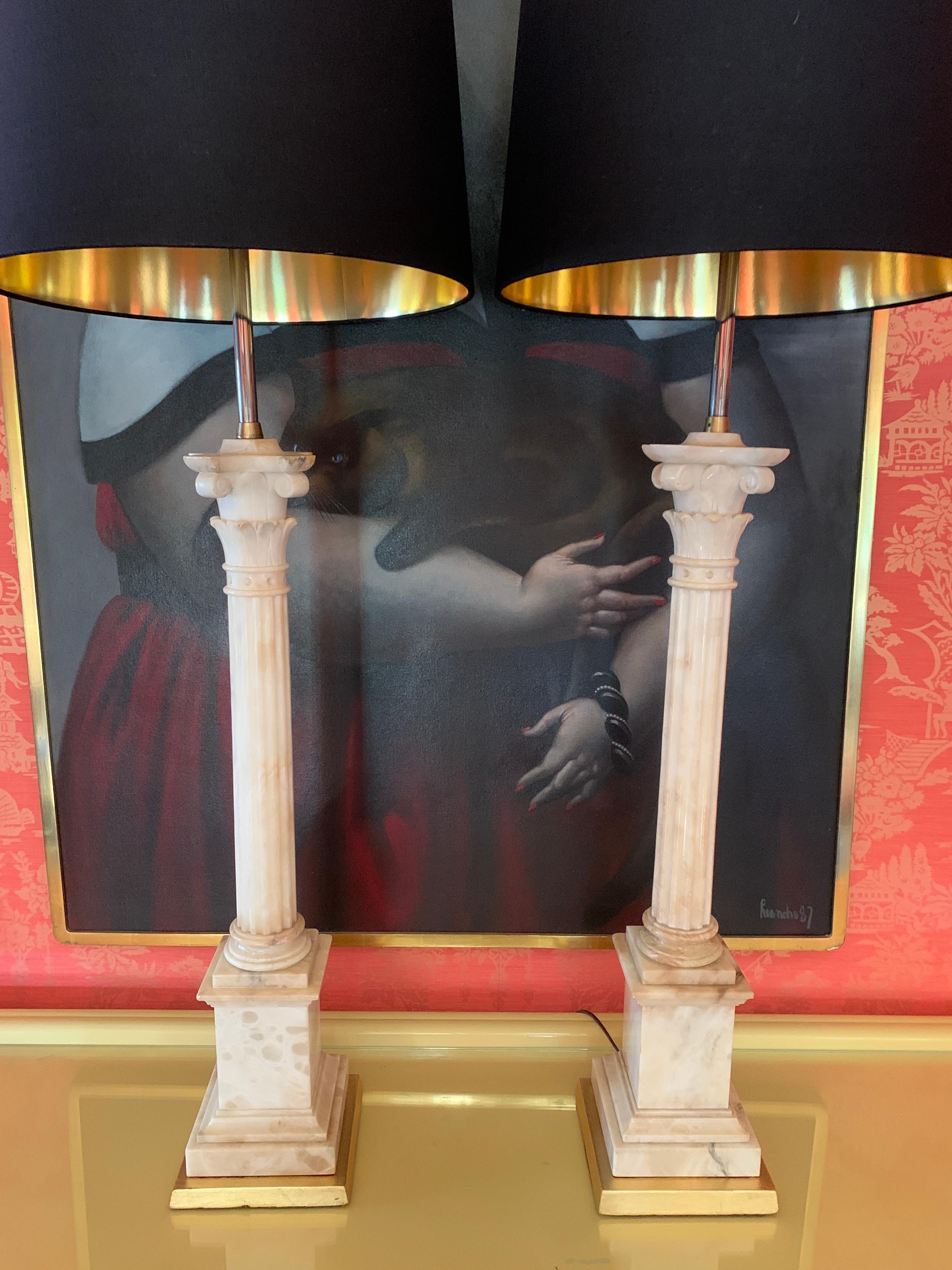 A spectacular pair of monumental marble ionic column lamps with gilt wooden bases and black silk shades with gold foil interior.
This pair are stunning, and demand a large presence. The height and form are some of the best we have seen. newly