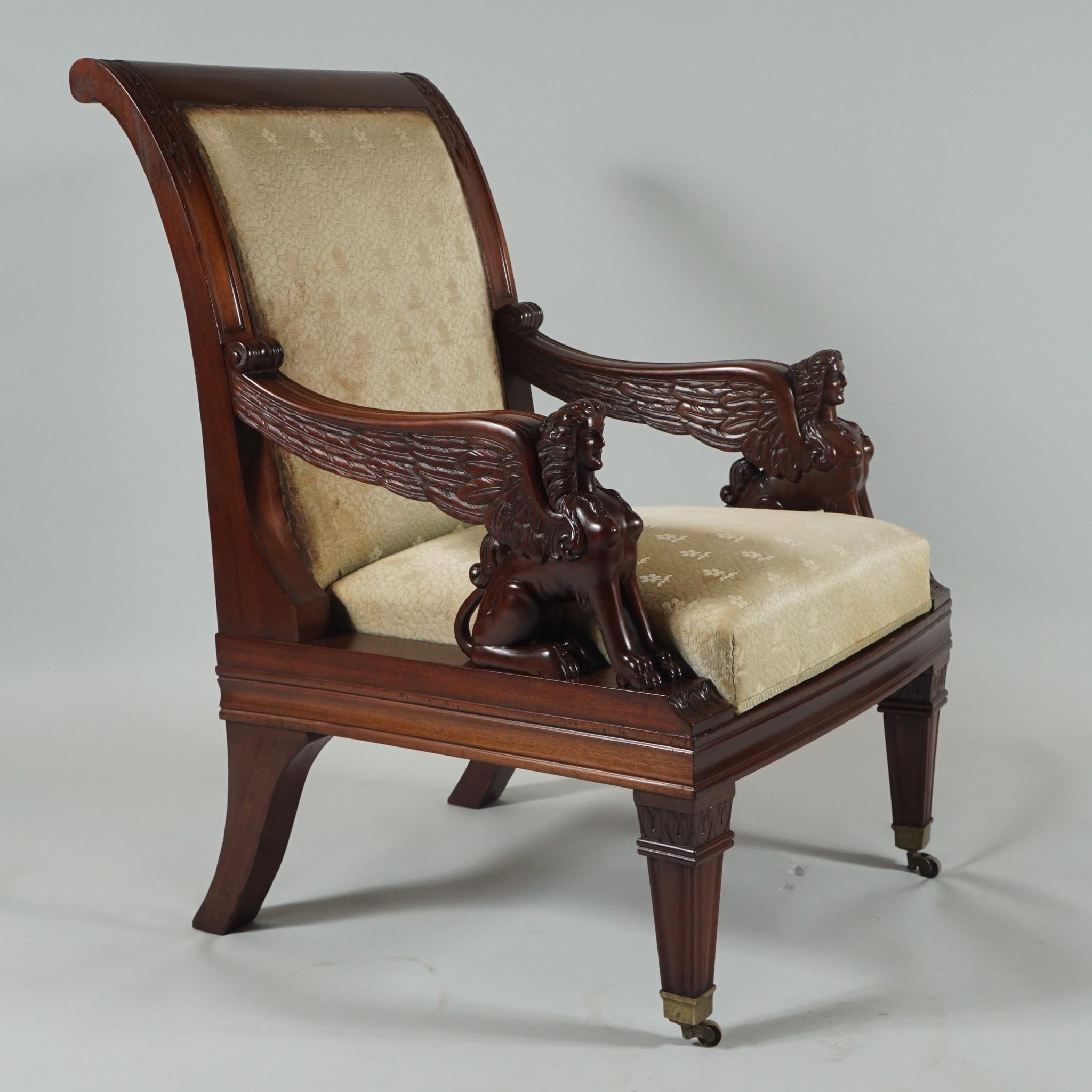Pair of handsome Egyptian Revival armchairs or library chairs in mahogany with 
elaborate hand-carved griffins on the arms. Front legs are on castors for easy moving. 

  