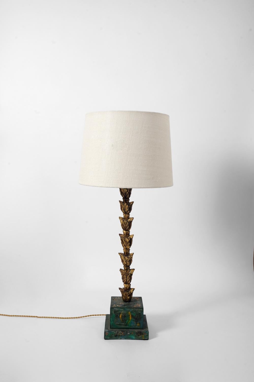 Pair of lamps in carved gilded wood with vegetal decoration resting on a column base with a square section in wood painted in trompe l'oeil imitating marble. France, 1920s.