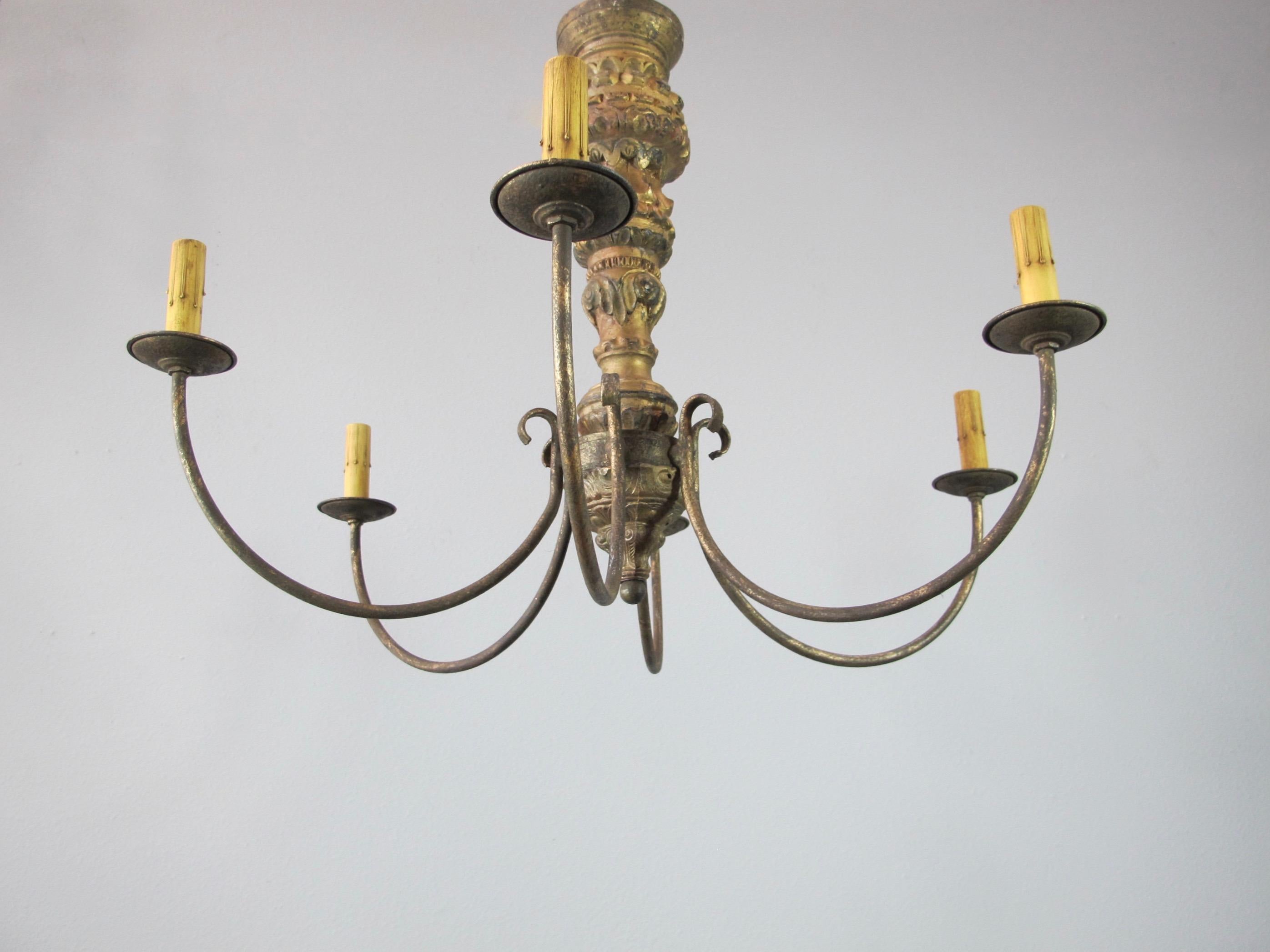 Matched pair of chandeliers created with highly carved gold gilt Italian candlesticks. The antique candlesticks are all original and were used as the base of the chandelier. The arms and bottom are new. Each chandelier has six candelabra base bulbs
