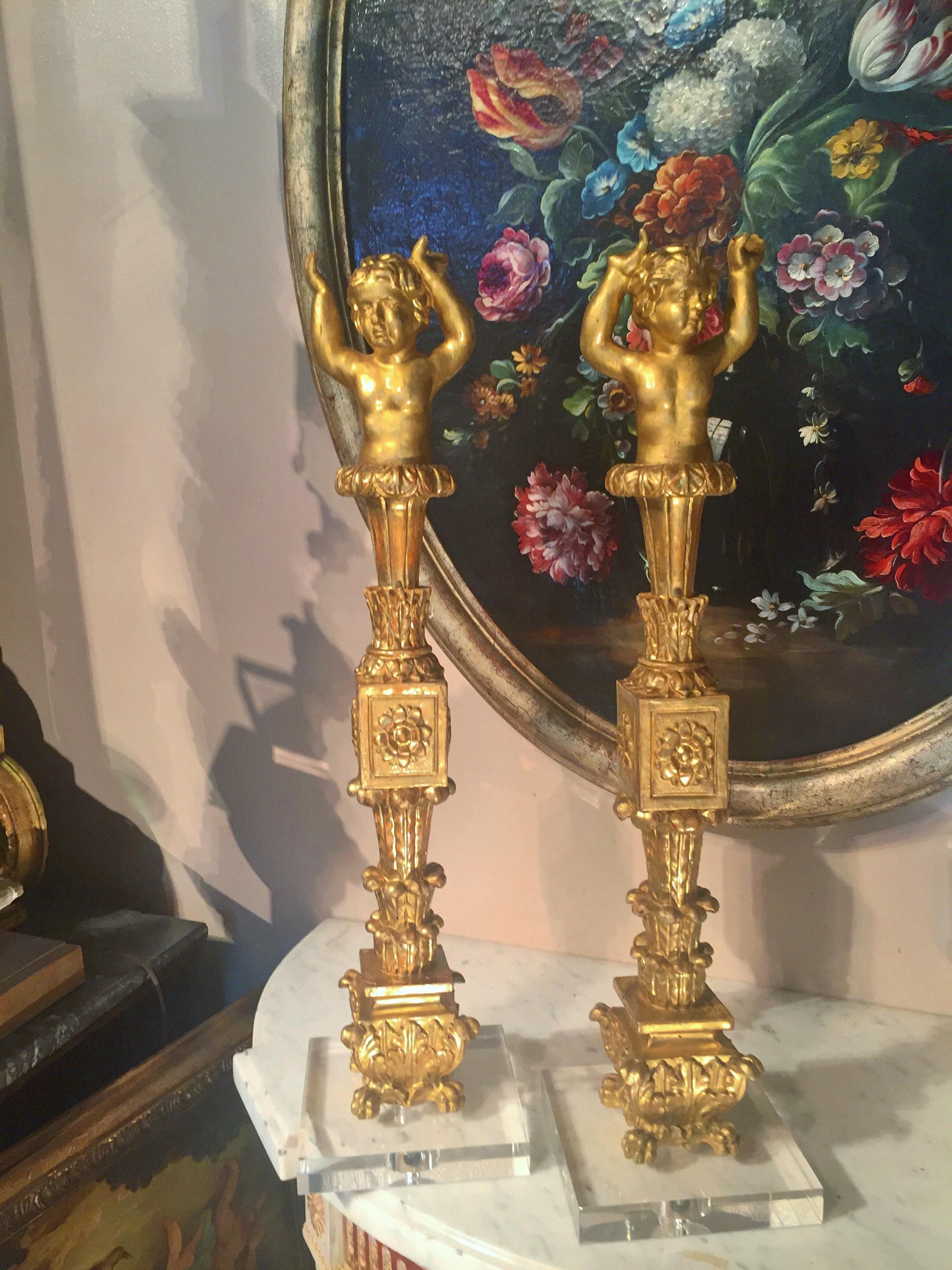 On acrylic bases (6 inch square ). Gilt and water gilt, cherubs on top of neoclassical stylized columns. 

Either off a cabinet or boiserie ( panelling ), the hands in upward support. Some fingers not missing but not finished as molding ran across