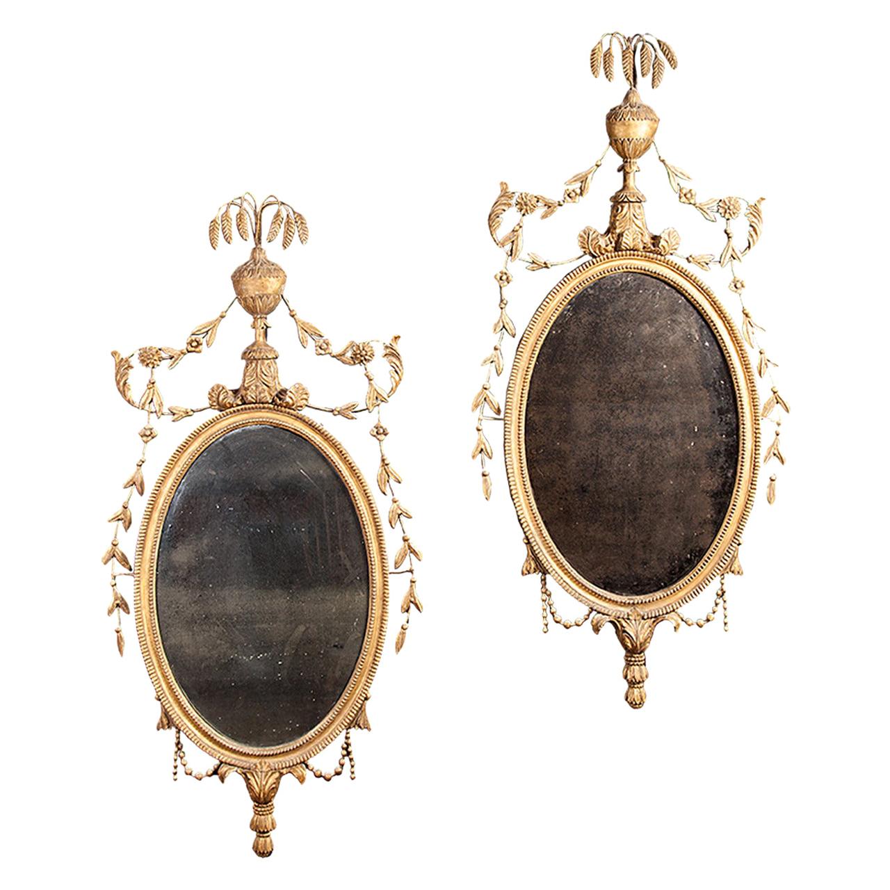 Pair of Carved Giltwood Neoclassical Oval Mirrors For Sale