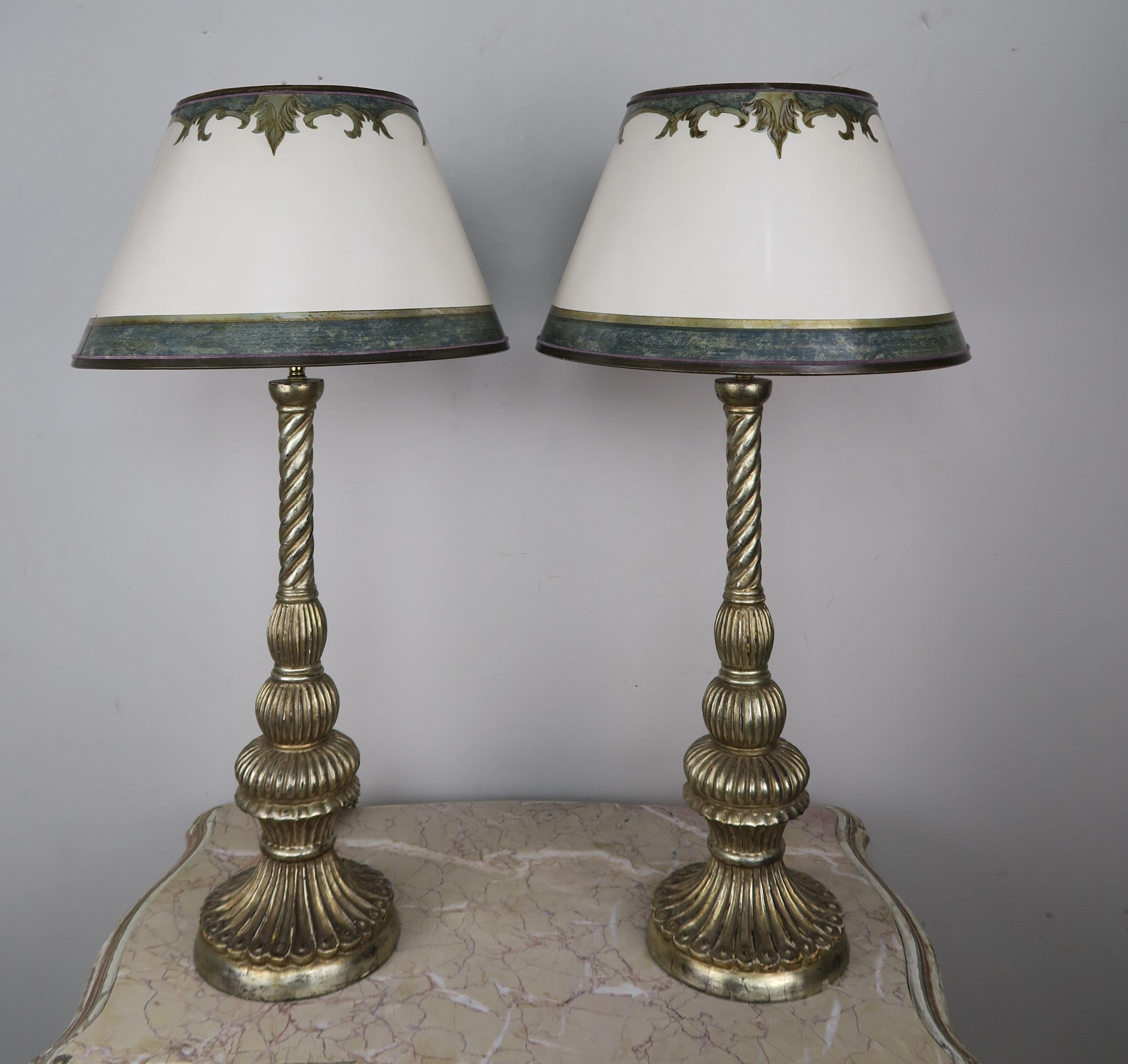 Pair of custom lamps made with carved wood antique Borghese finished bases crowned with hand painted parchment shades. The lamps are wired with double adjustable harps and are both in working condition.