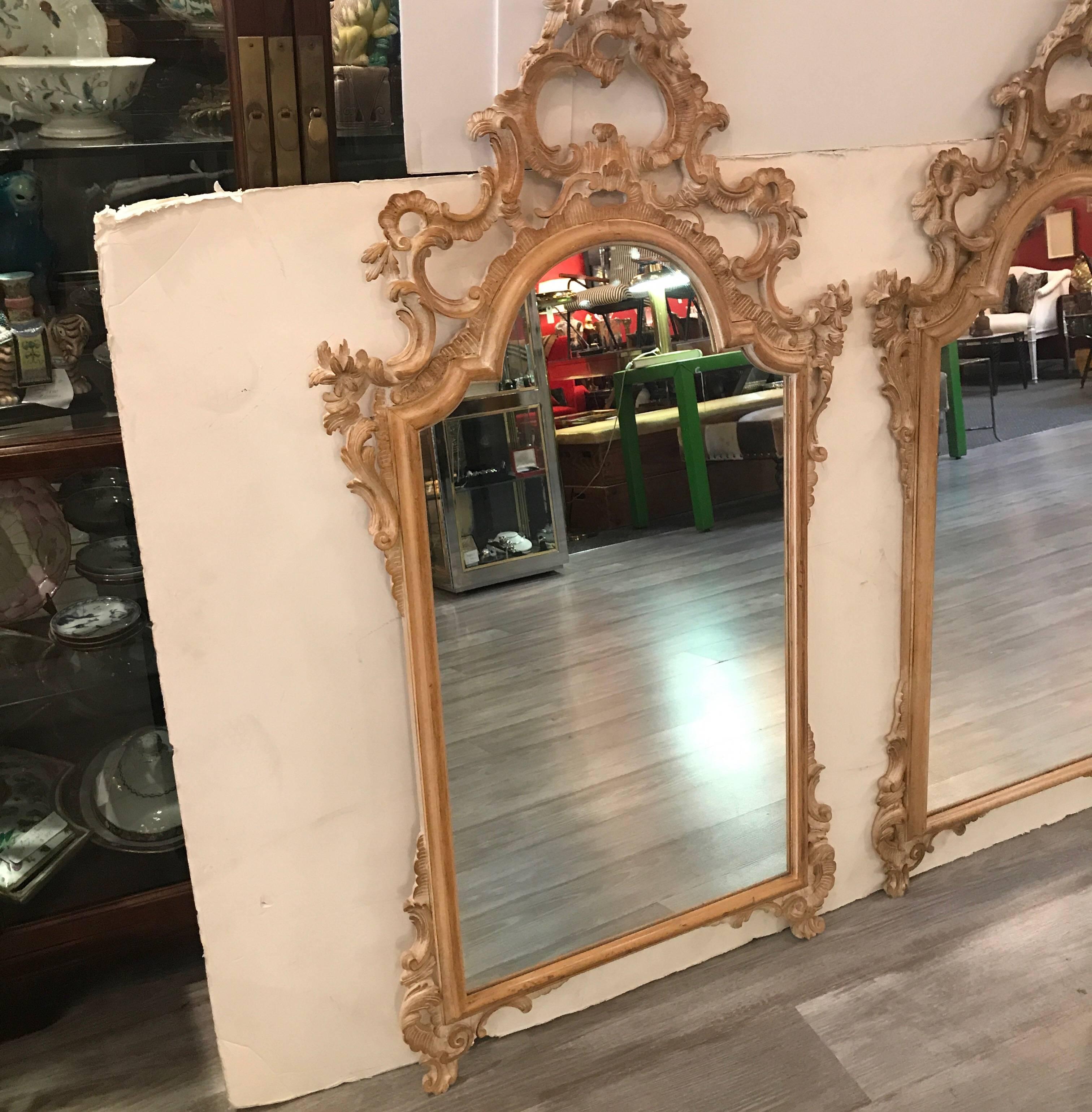 Elaborate pair of blonde and scrubbed finished Rococo mirrors, a rare pair. The Louis XV style but with a light and fresh lighter wood finish. Made in Italy, circa 1970s.