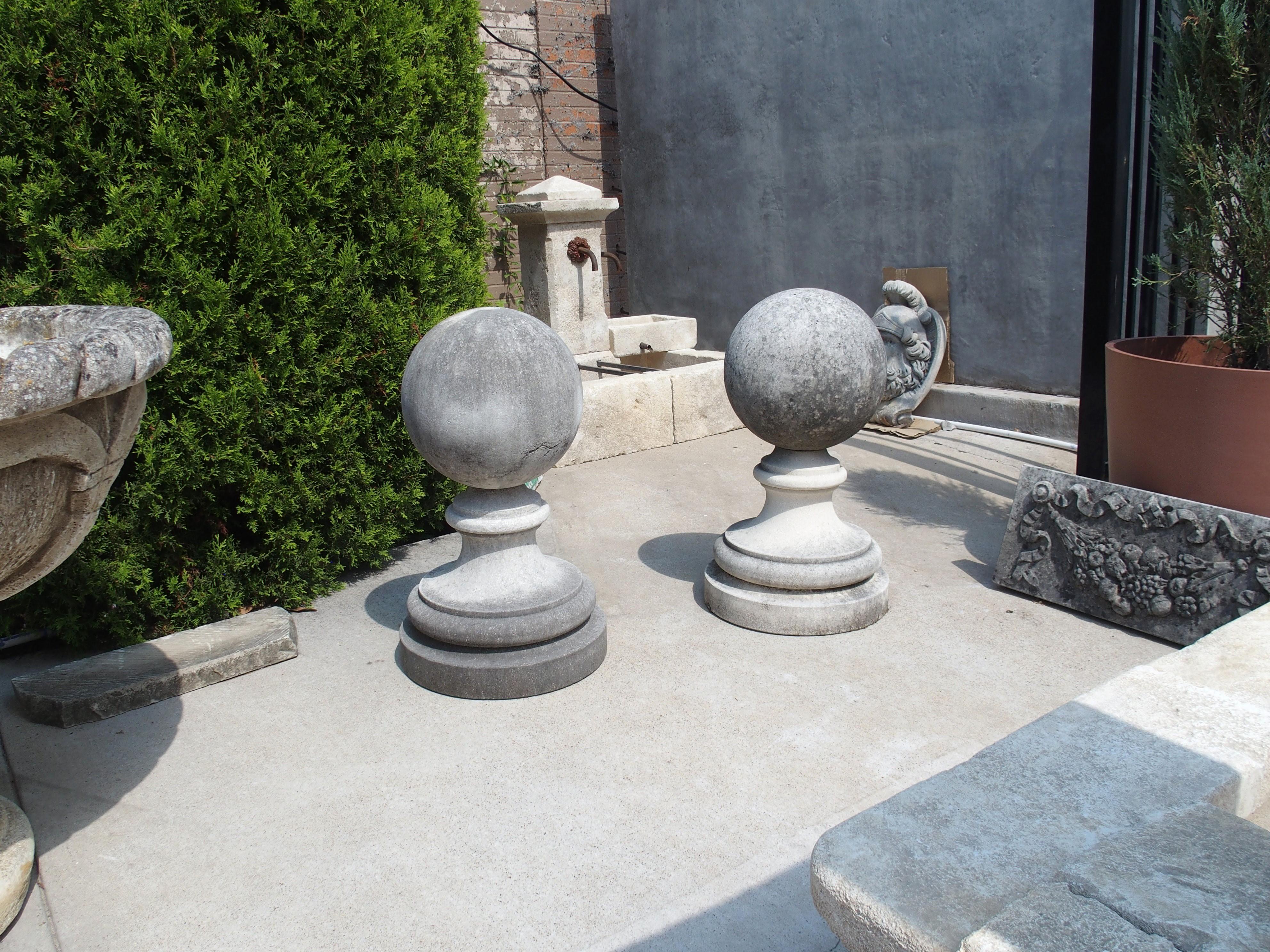Este gran par de remates de bola para jardín están tallados a mano en piedra caliza italiana. Ornamentos como éstos pueden verse a menudo flanqueando las entradas a los jardines de las villas italianas. De 27 pulgadas de alto, cada una de las bolas