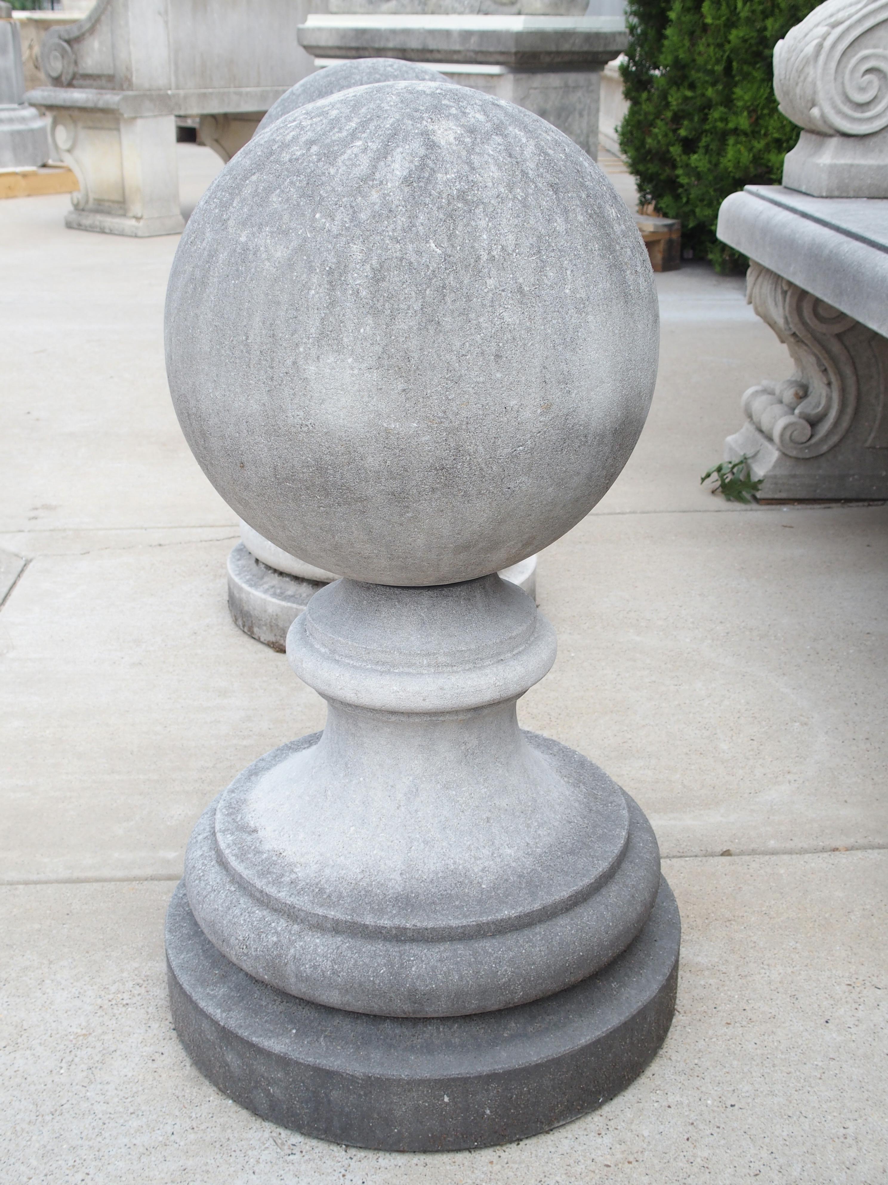 Cette grande paire d'embouts de jardin a été sculptée à la main dans du calcaire italien. De tels ornements sont souvent visibles à l'entrée des jardins des villas italiennes. D'une hauteur de 27 pouces, chacune des boules de 13 pouces de diamètre