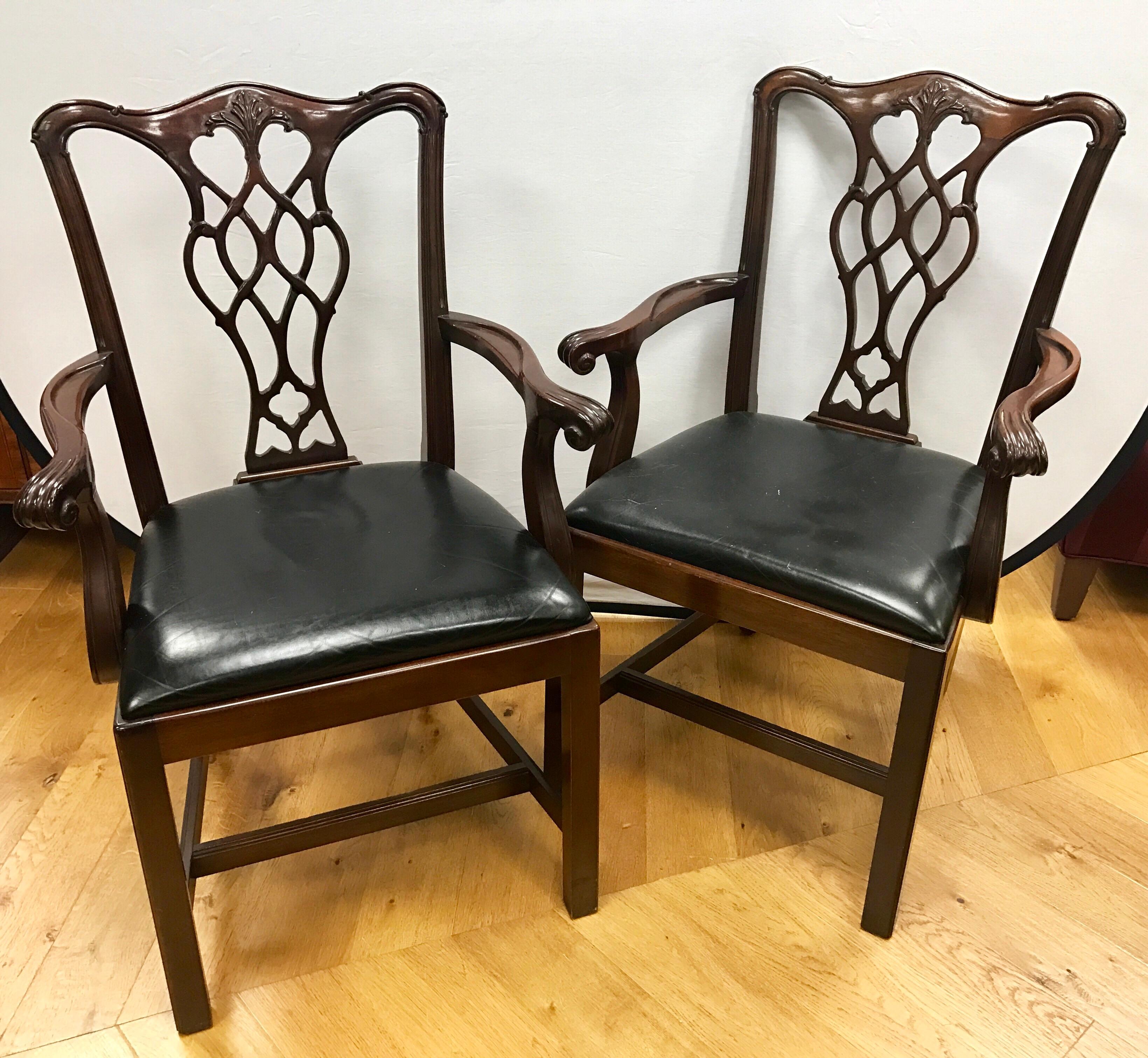 Elegant pair of matching Chippendale vintage mahogany armchairs with black vinyl seat cushions.
We have several sets of these.