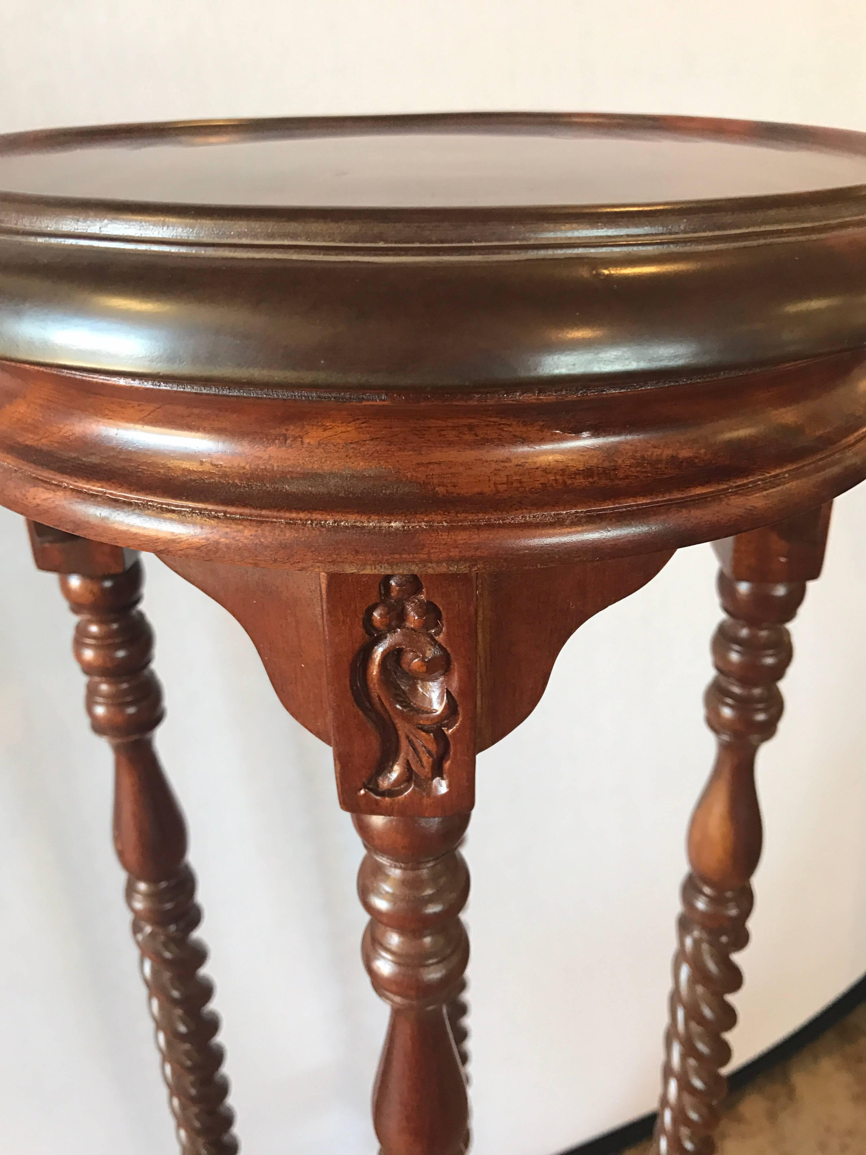 Pair of mahogany pedestals columns with intricate carving and turned legs.