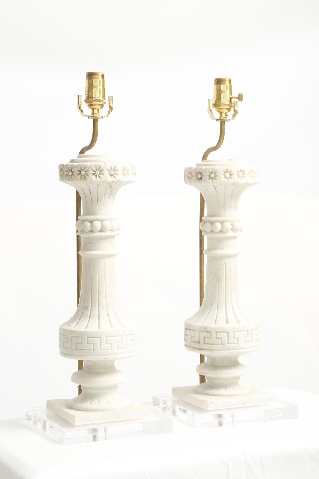 Pair of early balustrade fragments, of hand carved Carrara marble; each round column having a top-ring of rosettes, the Horn-form neck over a circle of beading, its sloped body finished with Greek-key Meander, on graduated socle, ending on a square