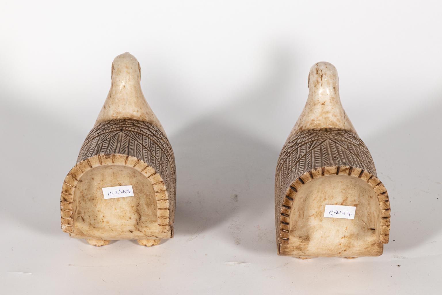 Pair of carved marble duck statues. Please note of wear consistent with age including discoloration and distressed finish.