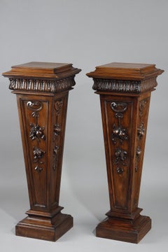 Paire de sellettes en noyer mouluré sculpté à décor de fruits et de plantes.