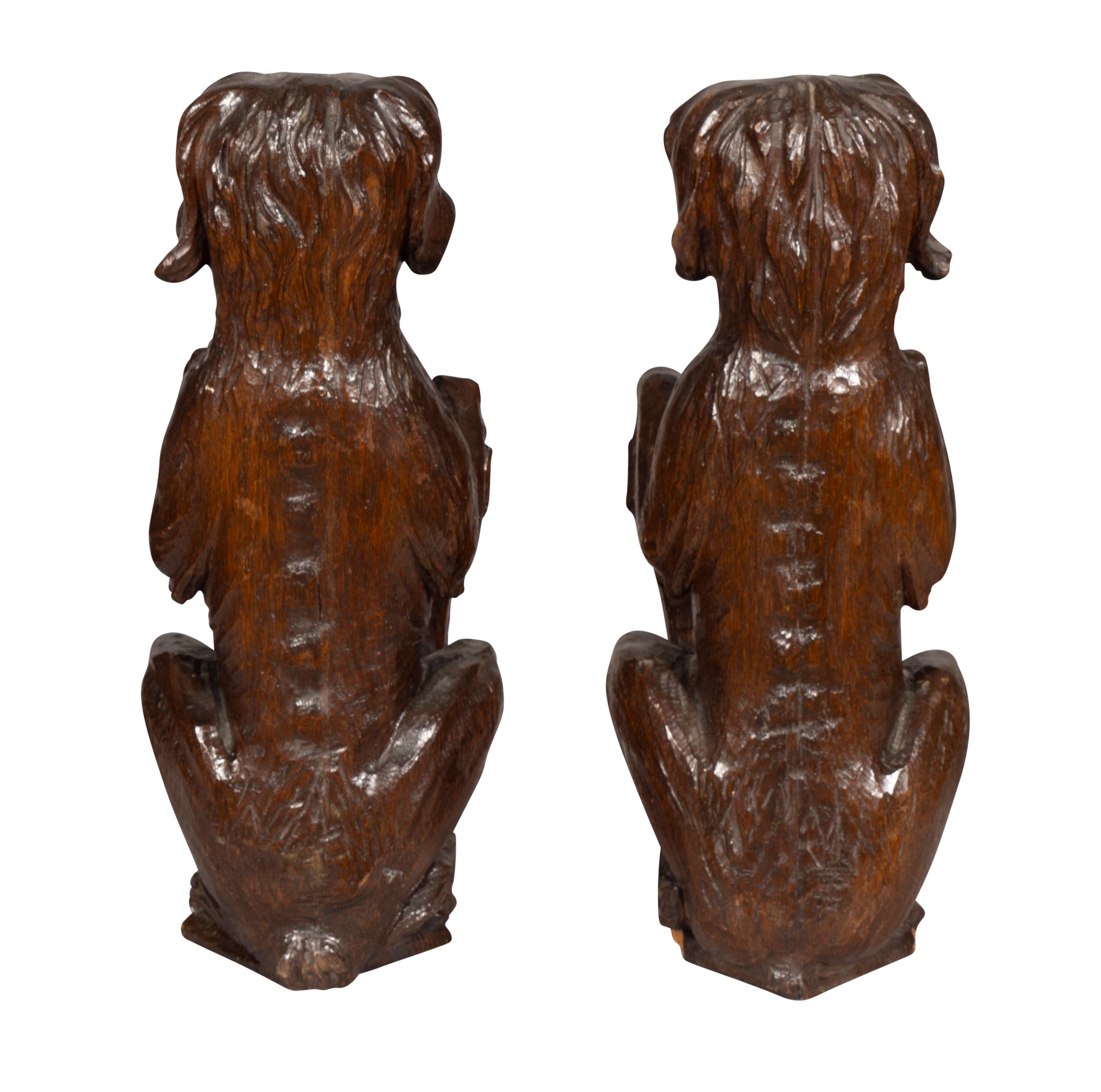Paar geschnitzte Eichenholzfiguren von sitzenden Hunden mit Schilden (Europäisch) im Angebot