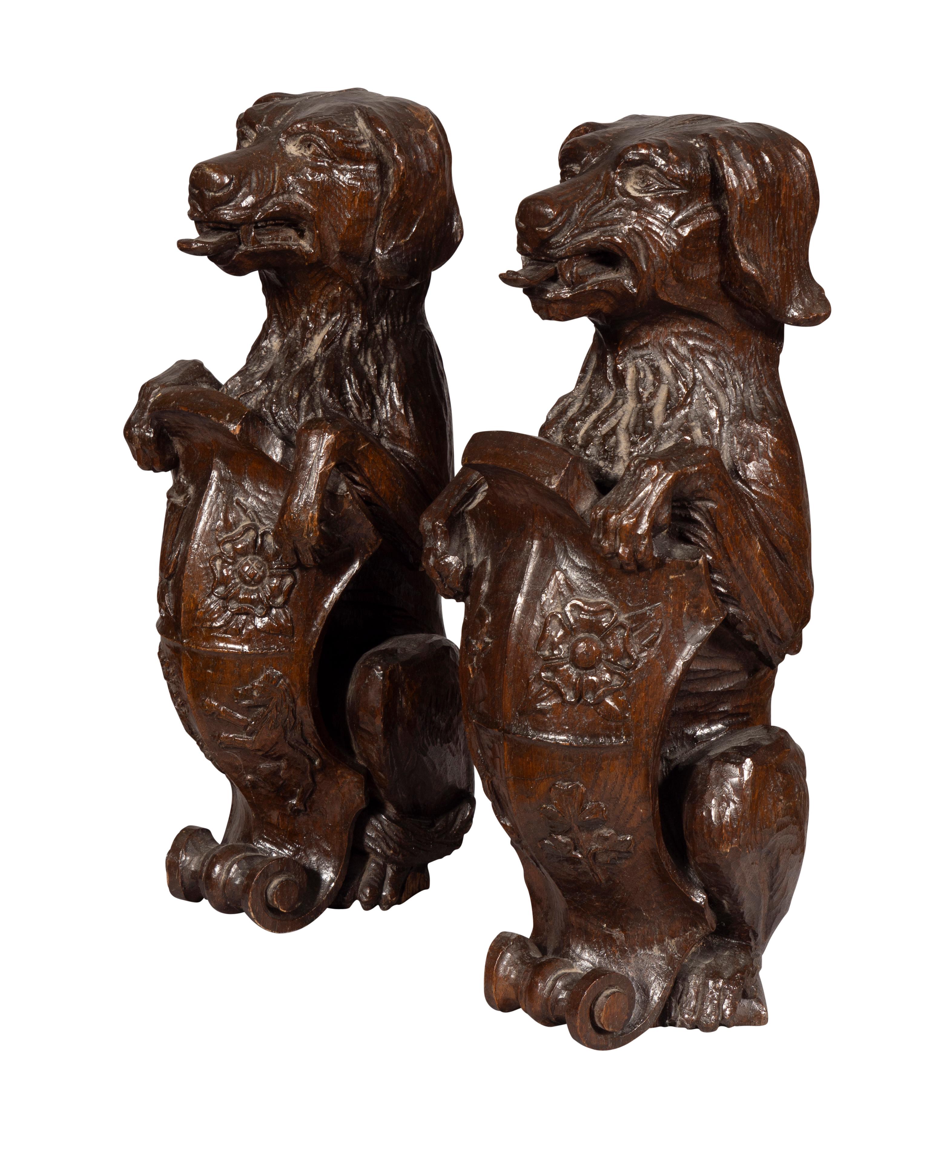 Paar geschnitzte Eichenholzfiguren von sitzenden Hunden mit Schilden (Spätes 19. Jahrhundert) im Angebot